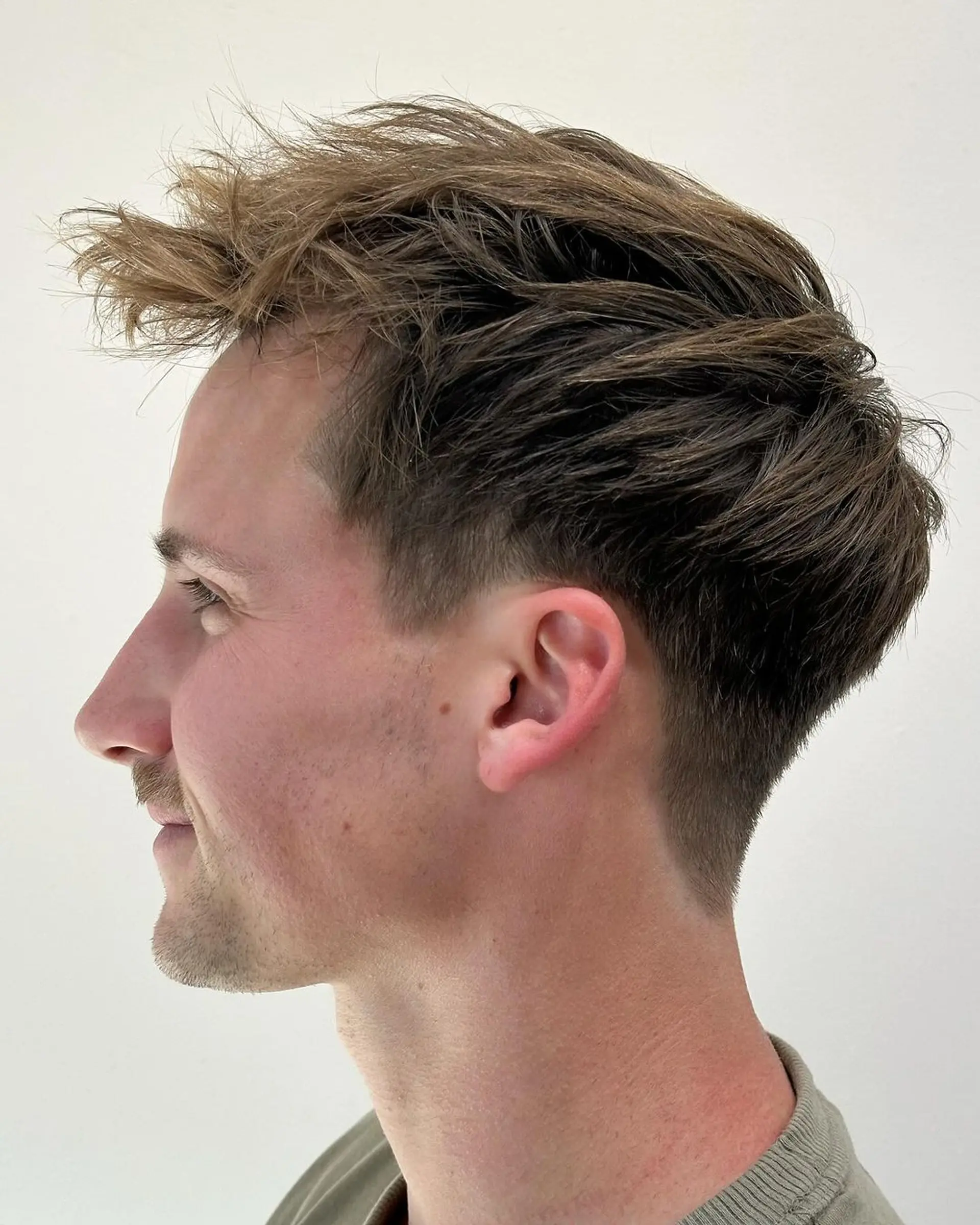 A textured tousle with a natural movement and soft lift on the top, complemented by an undercut side and tapered back. 1