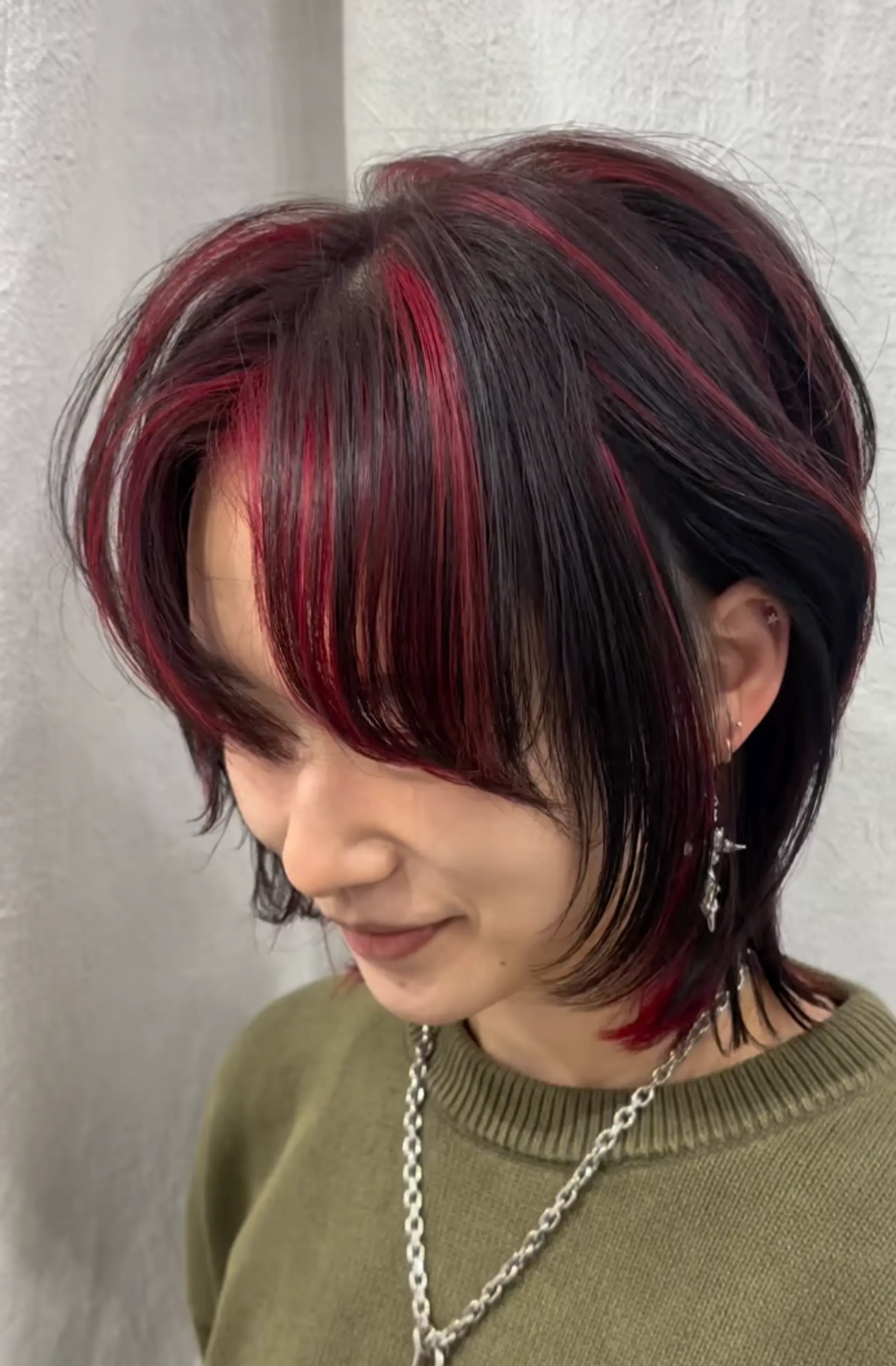 Medium-length straight hair with black and vibrant red colors, featuring layers and textured ends. Side bangs and asymmetrical cuts add modern elegance. 1