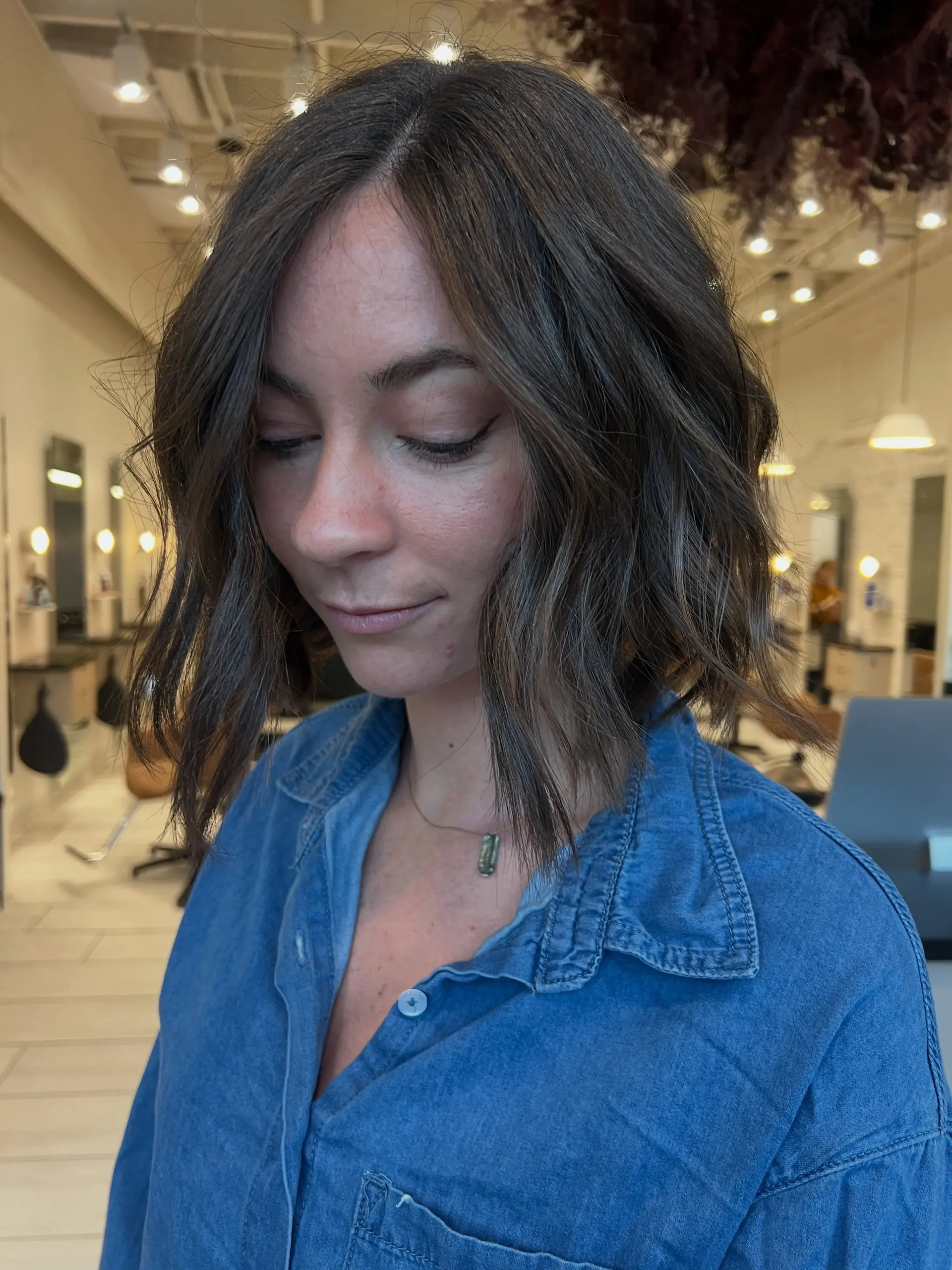 A textured chin-grazing bob styled with subtle waves and soft, natural brown highlights. 1