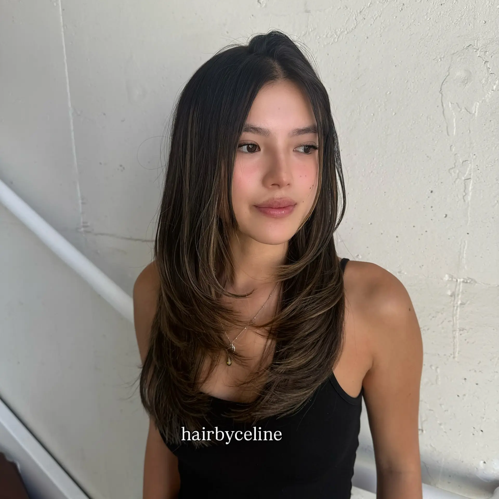 A butterfly cut with face-framing layers and subtle blonde balayage. 1