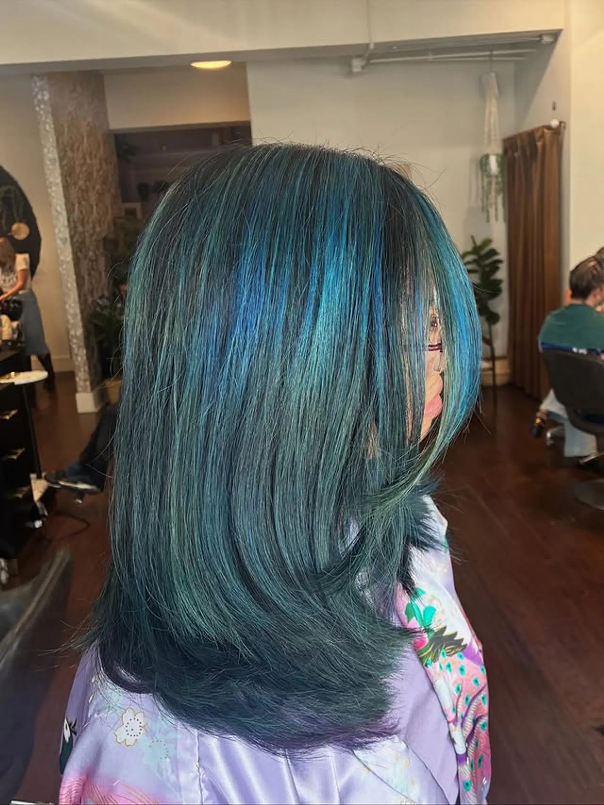 A vibrant medium-length straight hairstyle with a color melt from dark teal to brighter blues. 1