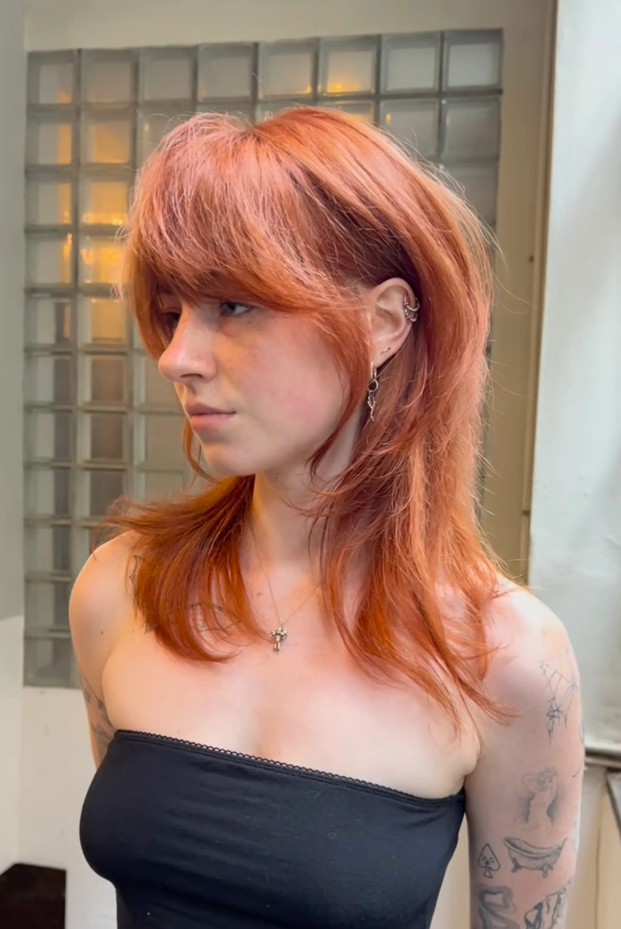 The 'Fiery Cascade' features straight, medium-length copper red hair characterized by layered cuts and feathered bangs, adding volume and dimension with textured ends. 1
