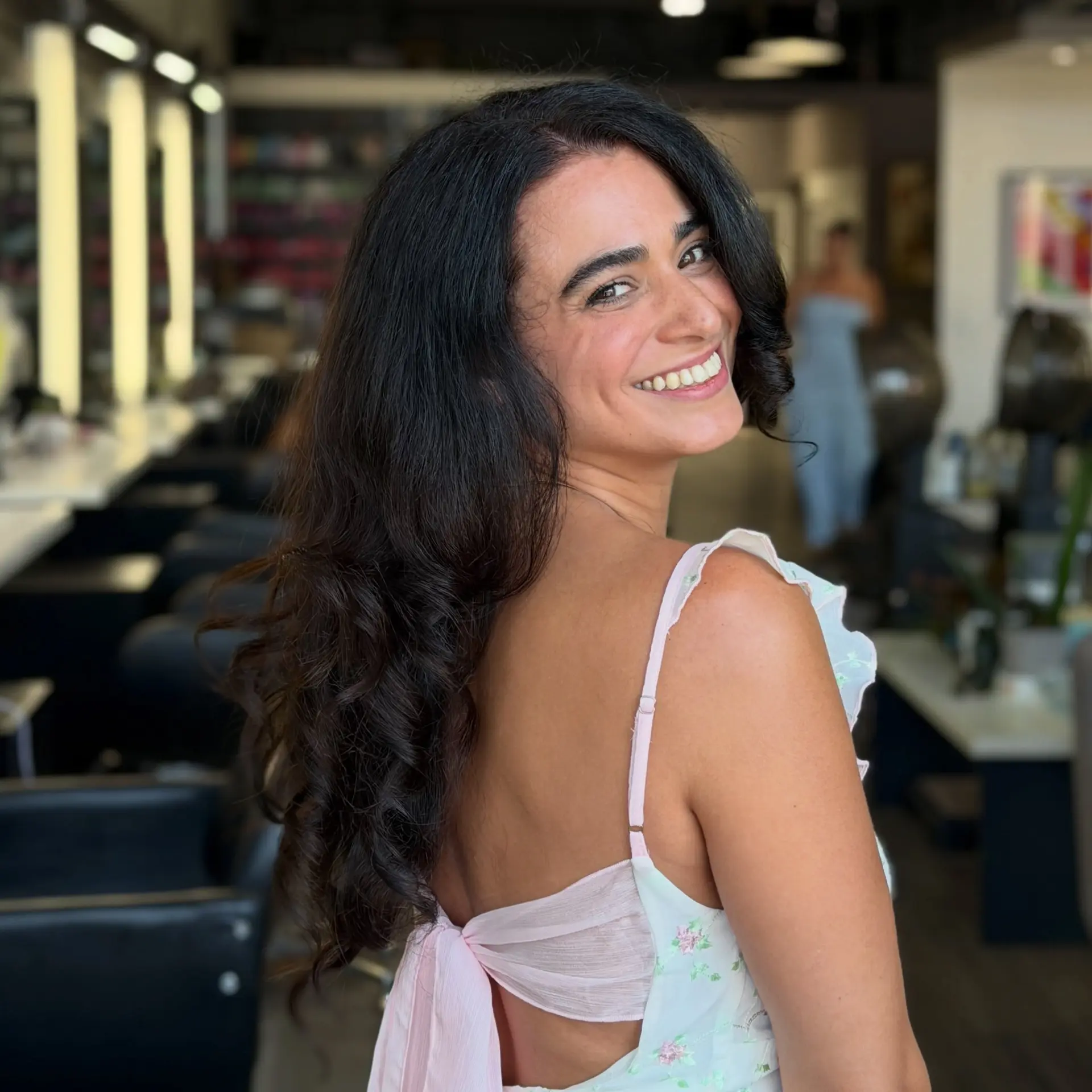 A voluminous blowout styled with soft, defined curls tumbling down the back for elegant body and shine. 1