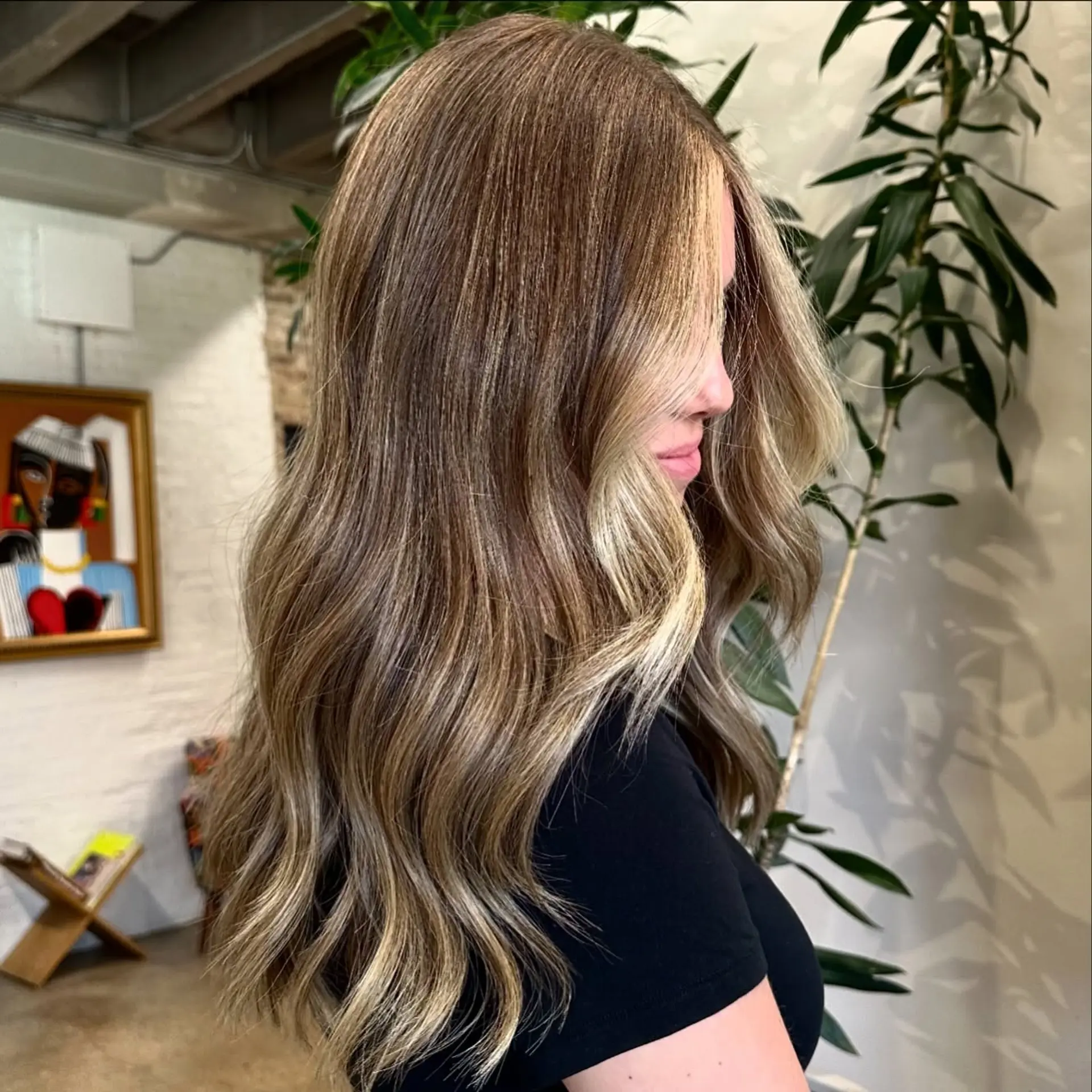 Long, layered waves with a seamless balayage color melt from brown to blonde. 1