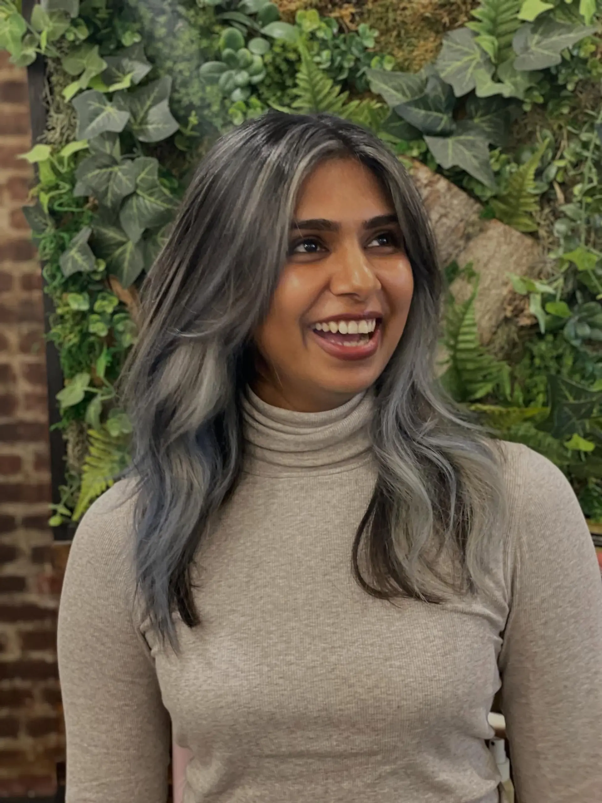 Medium-length layered hairstyle styled with soft loose waves and striking cool smoky silver highlights against a dark base. 1