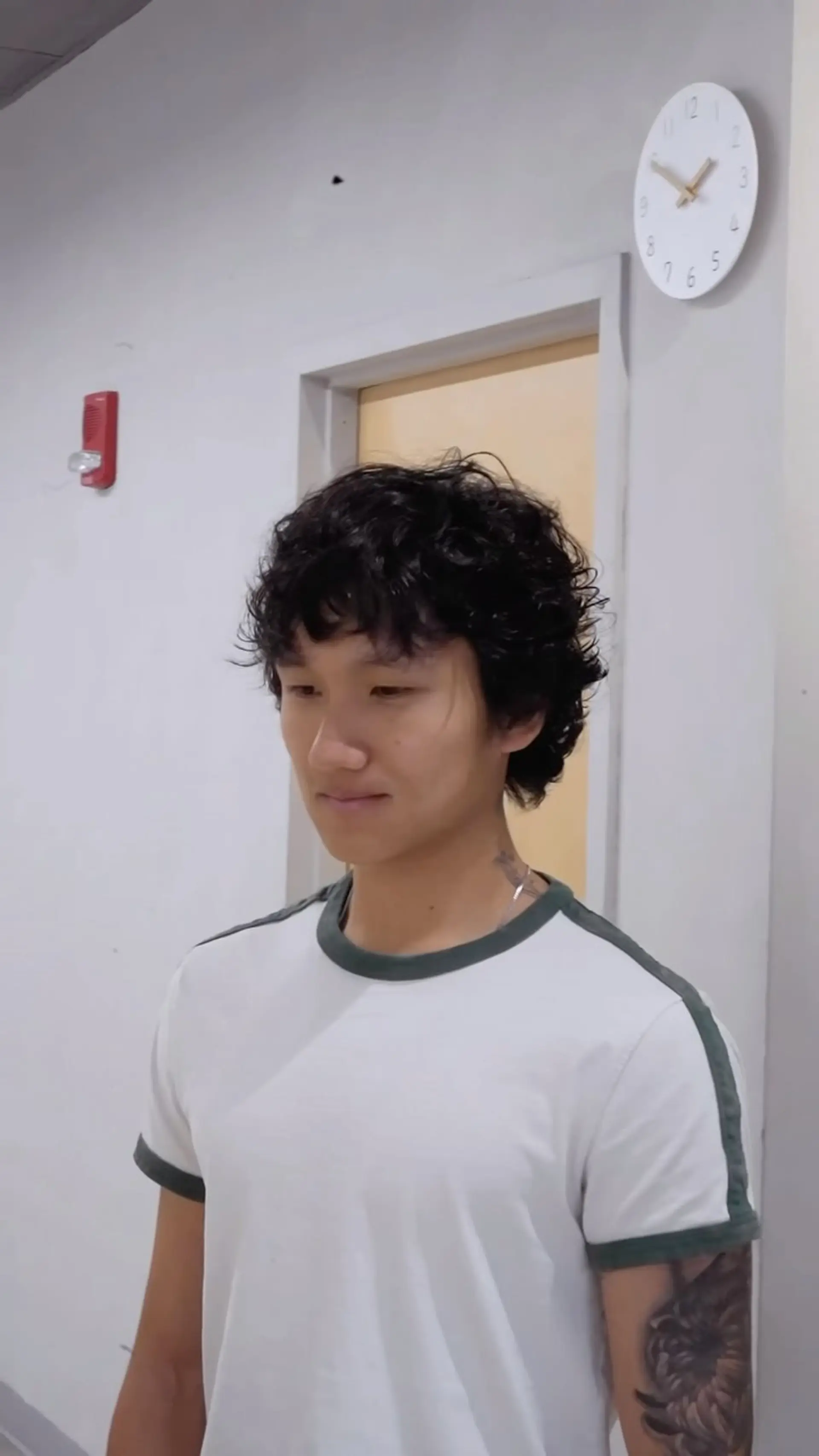 A men's short layered haircut featuring soft wavy texture, full volume, and light tousled curls falling across the forehead. 1