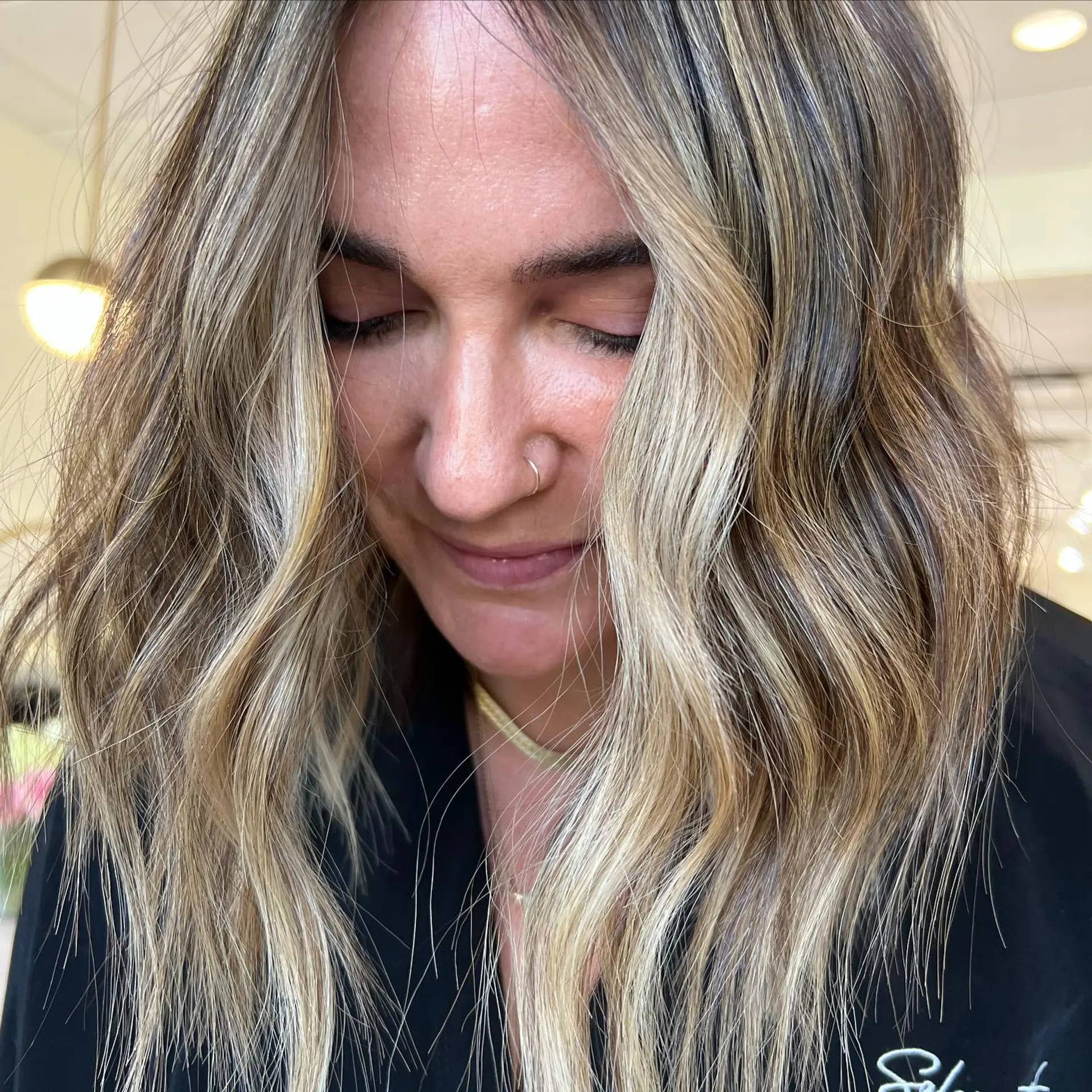 Medium-length textured waves featuring bright blonde balayage and sun-kissed, face-framing highlights over a neutral base. 1