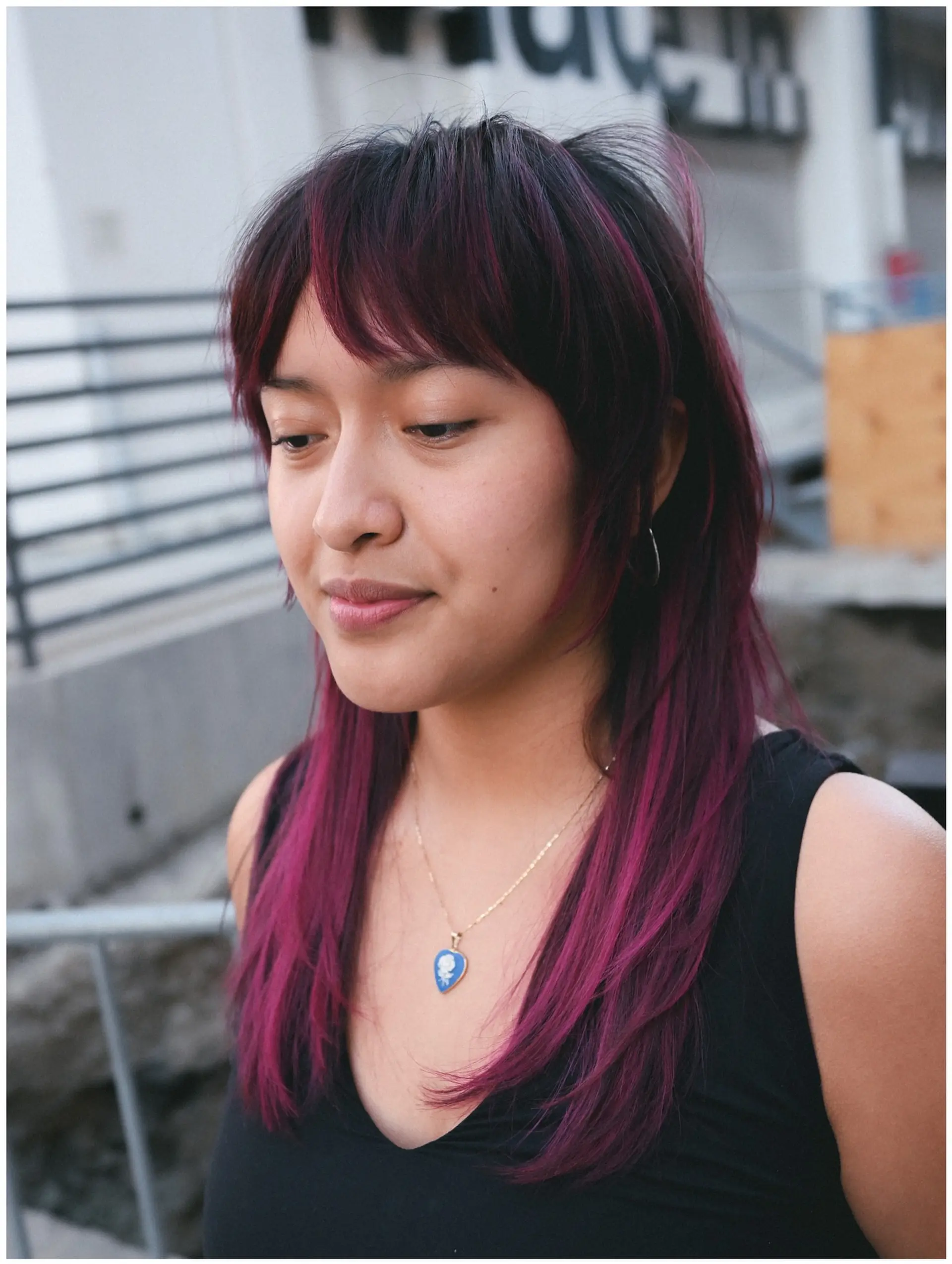 A medium-length modern shag with choppy curtain bangs, face-framing layers, and vivid magenta streaks over a dark base. 1