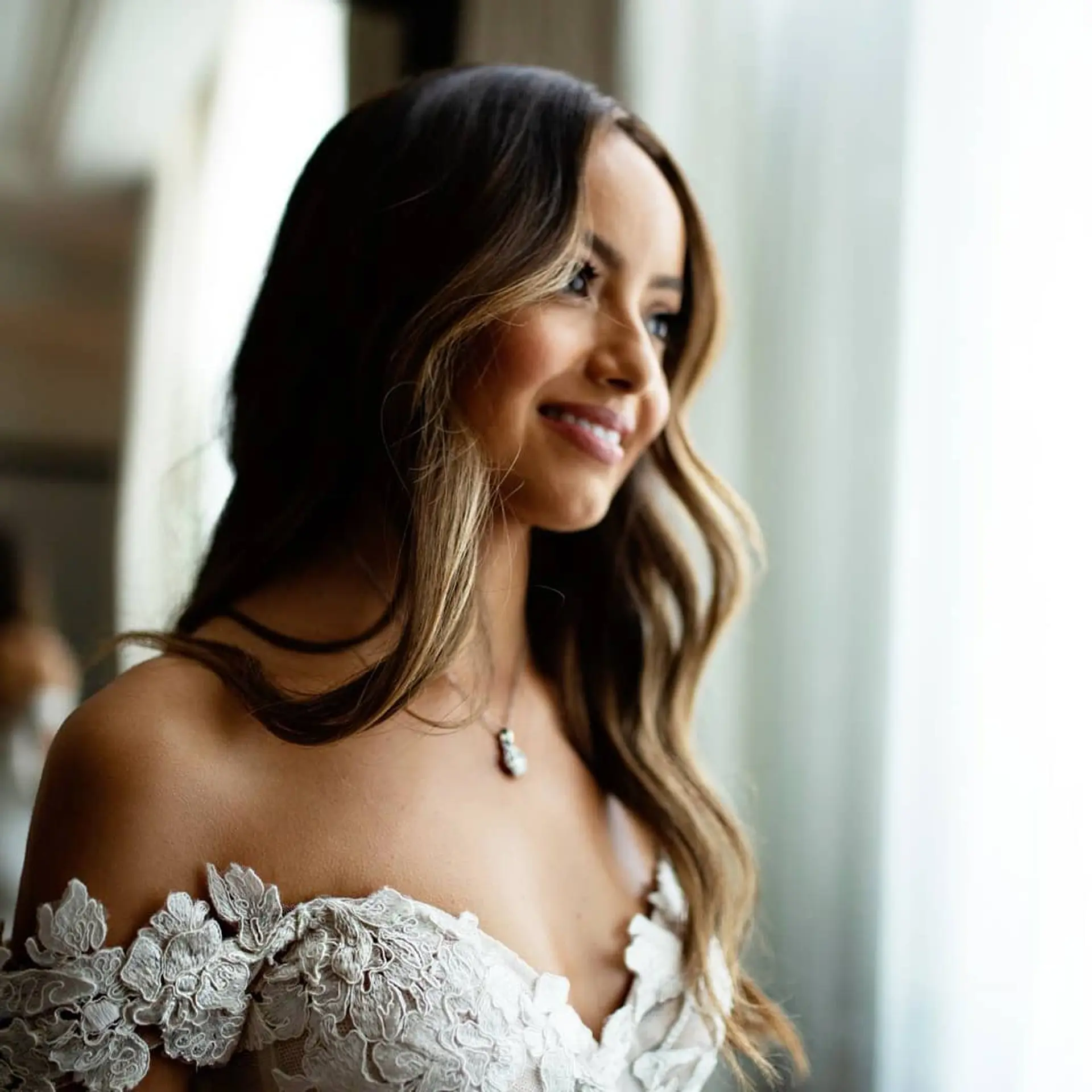 Long cascading waves featuring a soft brunette-to-blonde balayage with face-framing lighter strands. 1