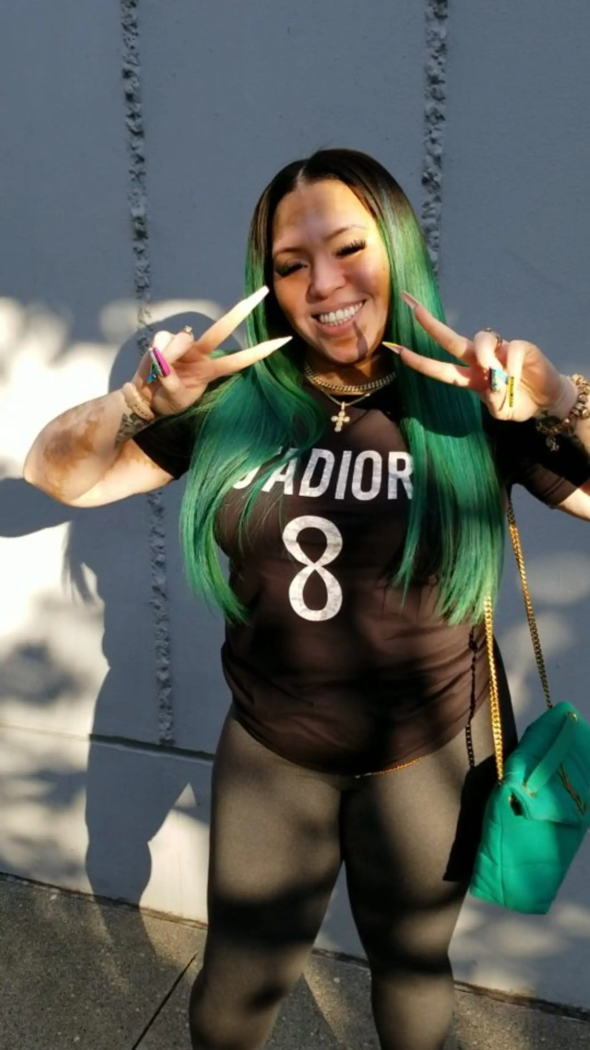 Long, sleek straight hair dyed in a vivid emerald green fashion color with dark shadow roots. 1