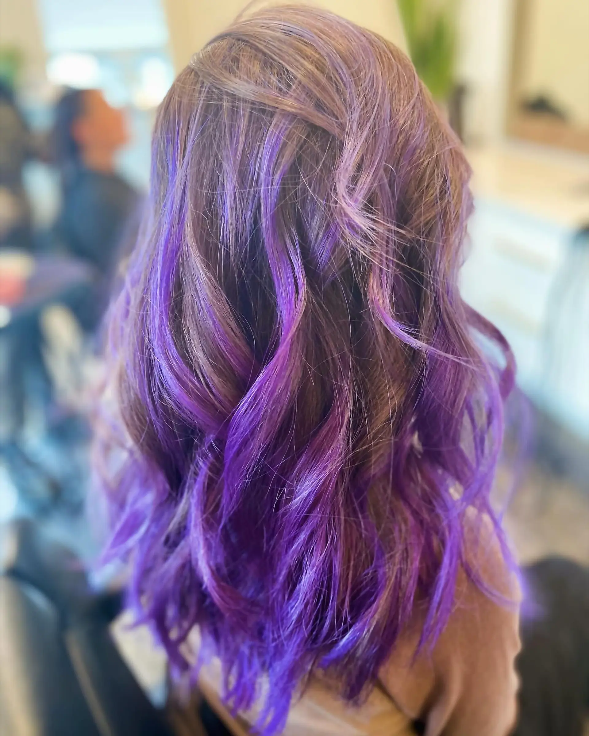 Long layered waves featuring vivid purple and violet ribbons blended through light brown hair. 1