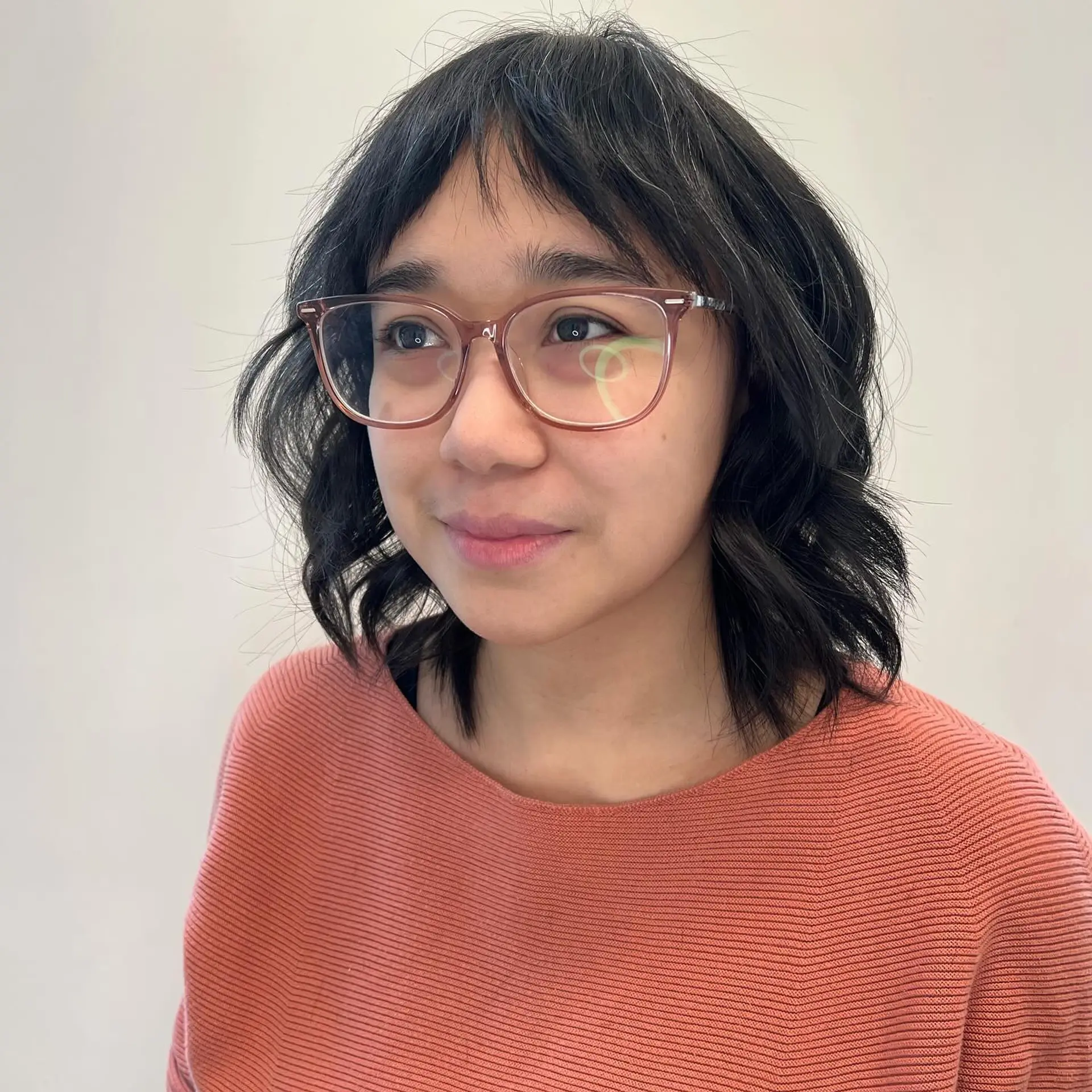 A textured chin-to-collarbone bob styled with soft waves and choppy, piecey micro bangs. 1