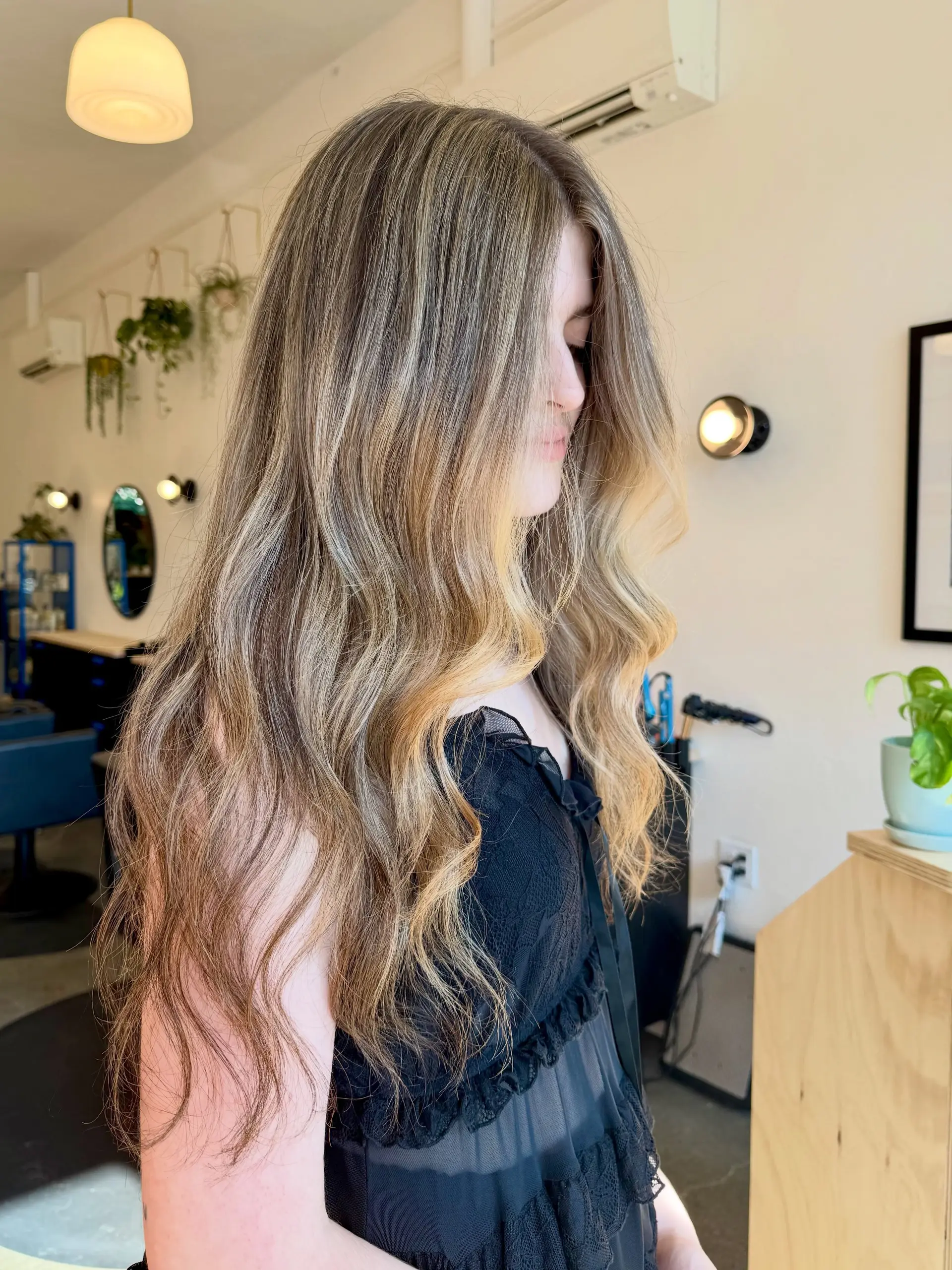 Long hair featuring dimensional golden blonde highlights, finished in soft, loose waves. 1