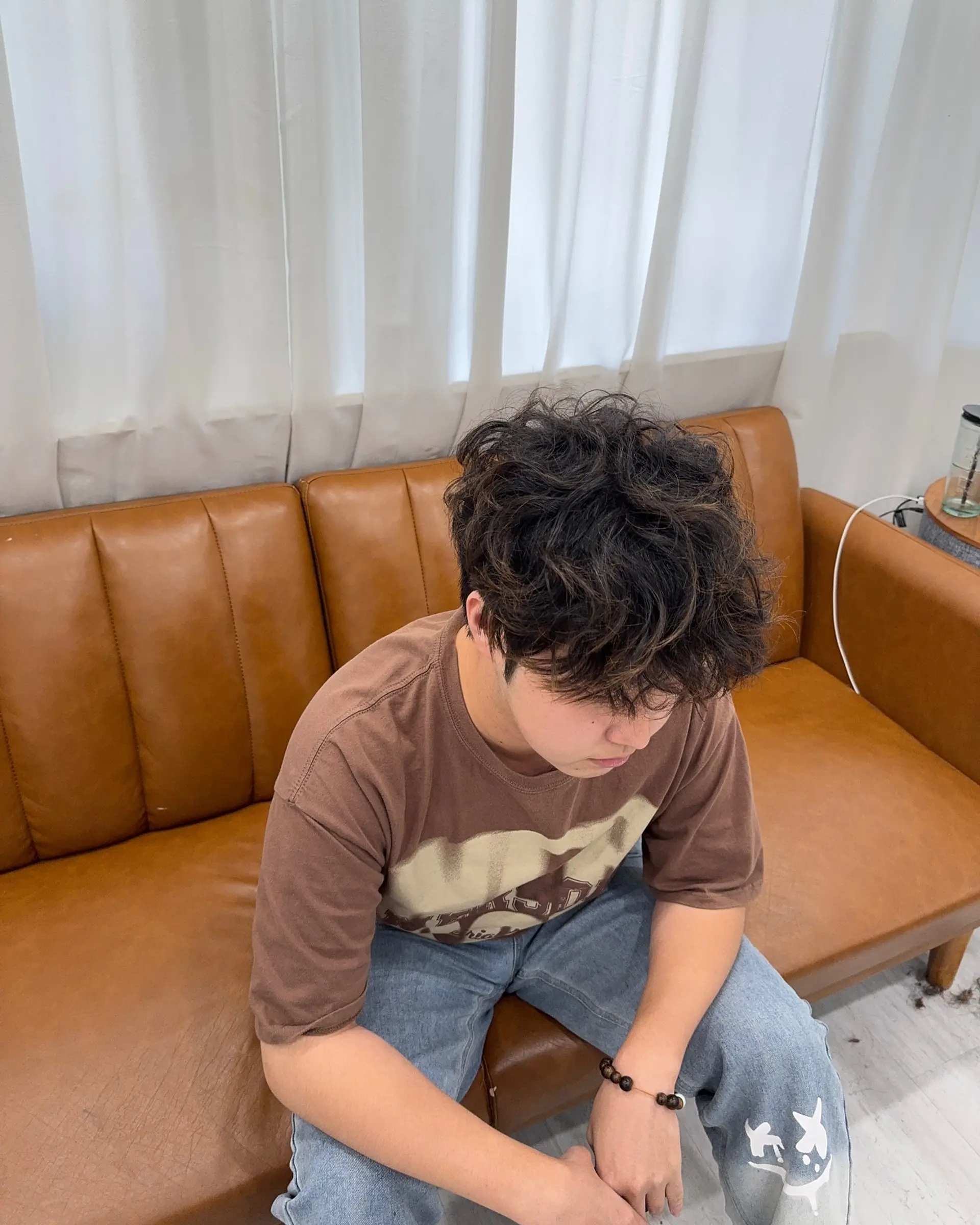 A stylish medium-length curly hairstyle featuring a modern Korean perm for a textured and fashionable look. 2