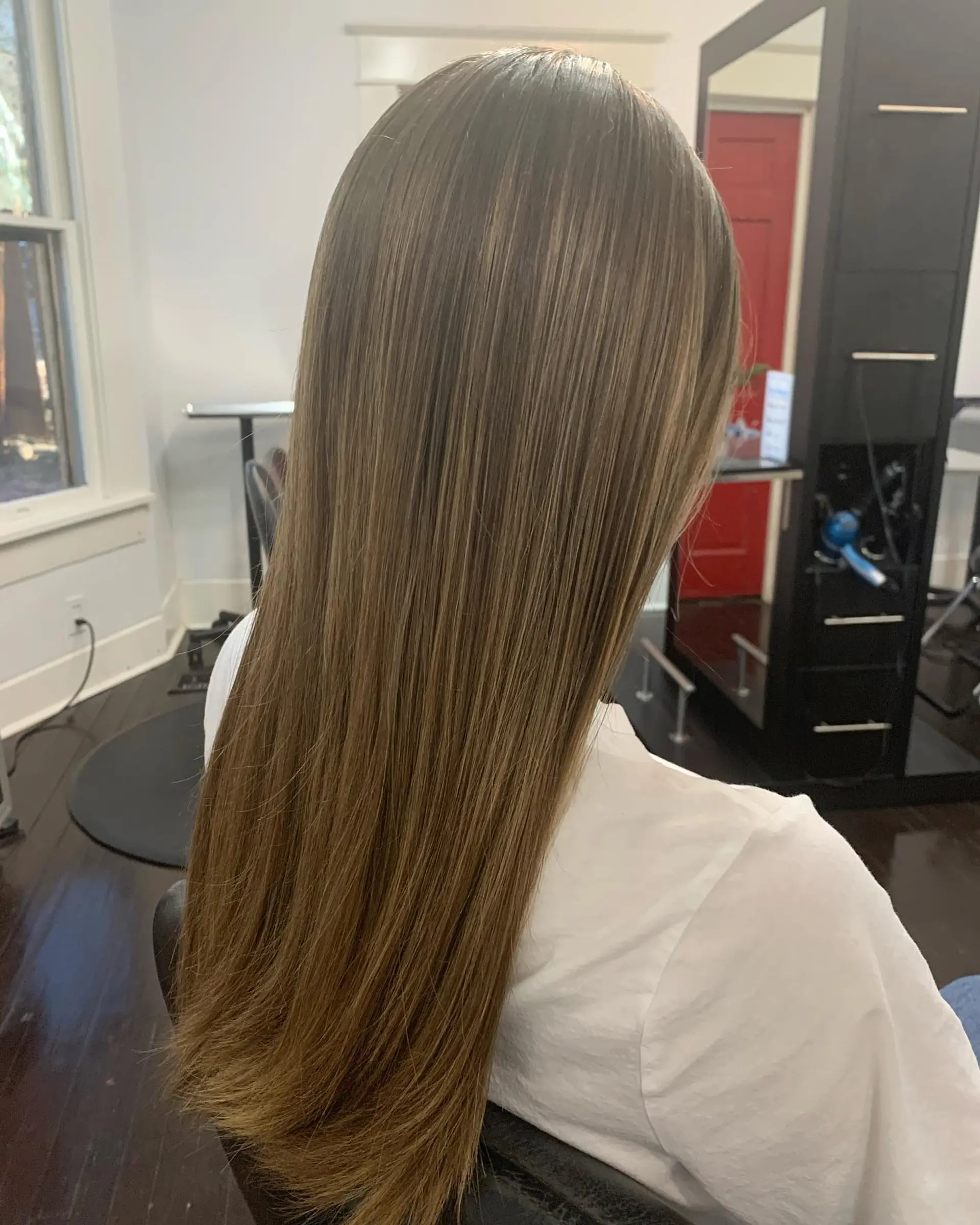 A sleek, smooth long haircut styled straight with soft, clean ends and fine dimensional highlights. 1