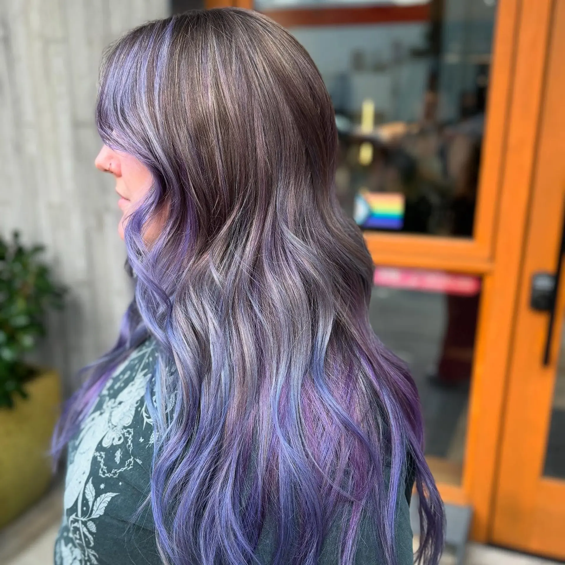 Long wavy hair with vibrant lavender and purple babylights blended into an ash brown base. 1