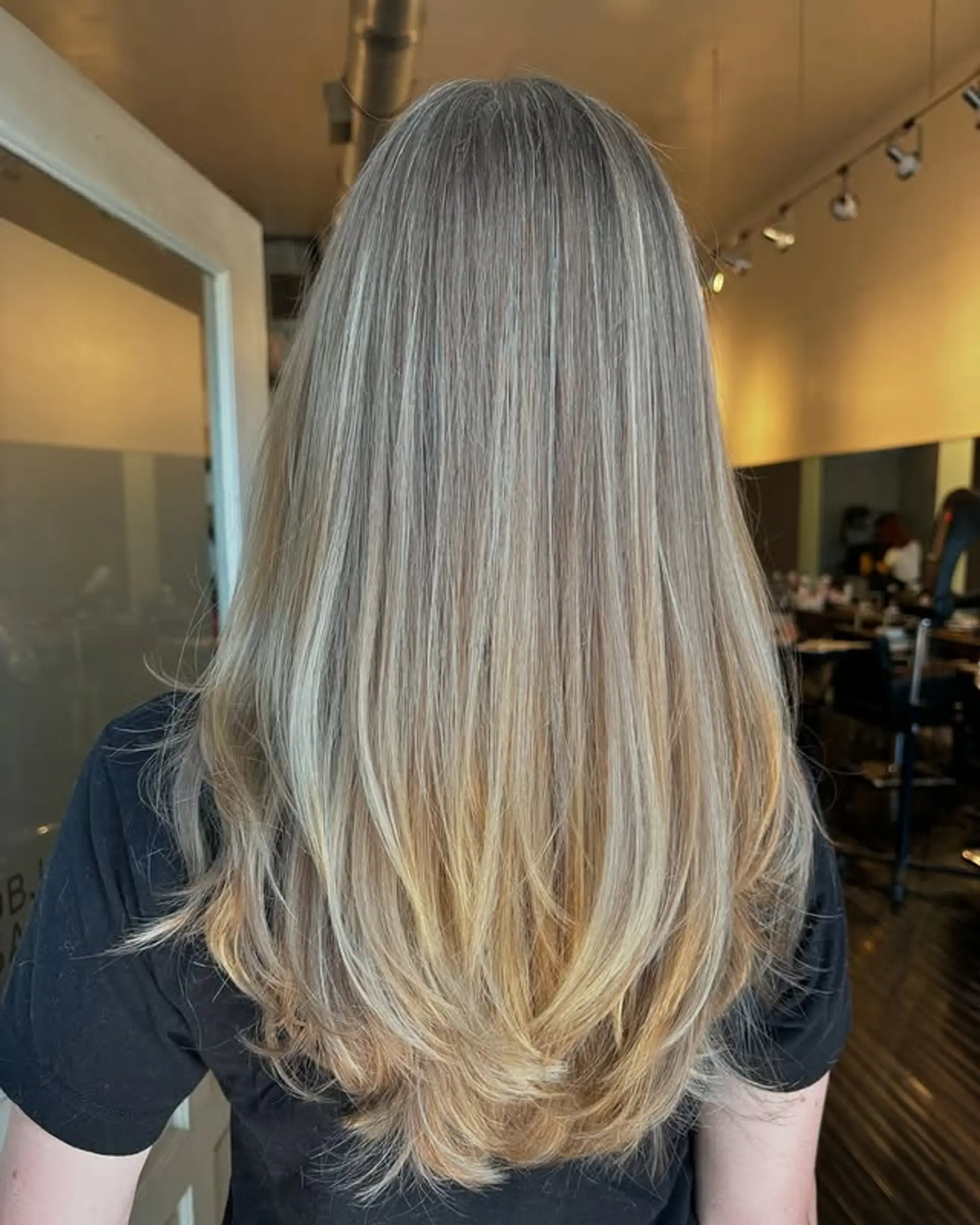 Long layered hairstyle with a balayage color technique, creating a soft ombre effect. 1