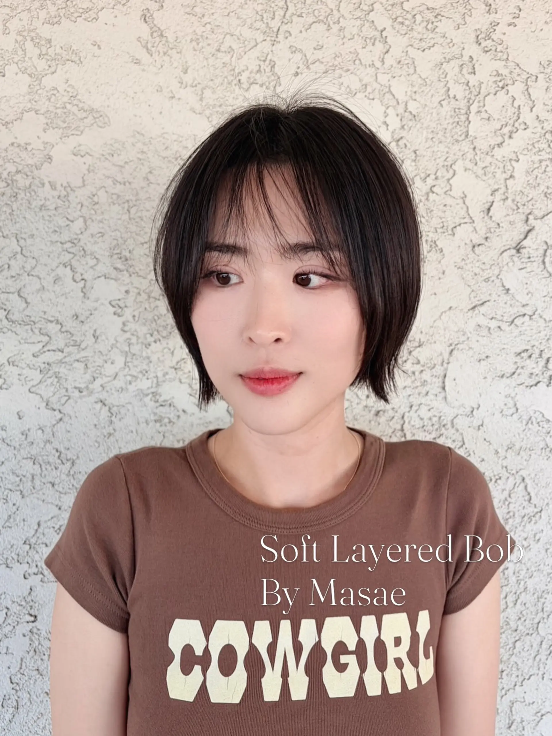 A soft, chin-length layered bob featuring airy, see-through bangs and subtle textured ends that frame the face. 1