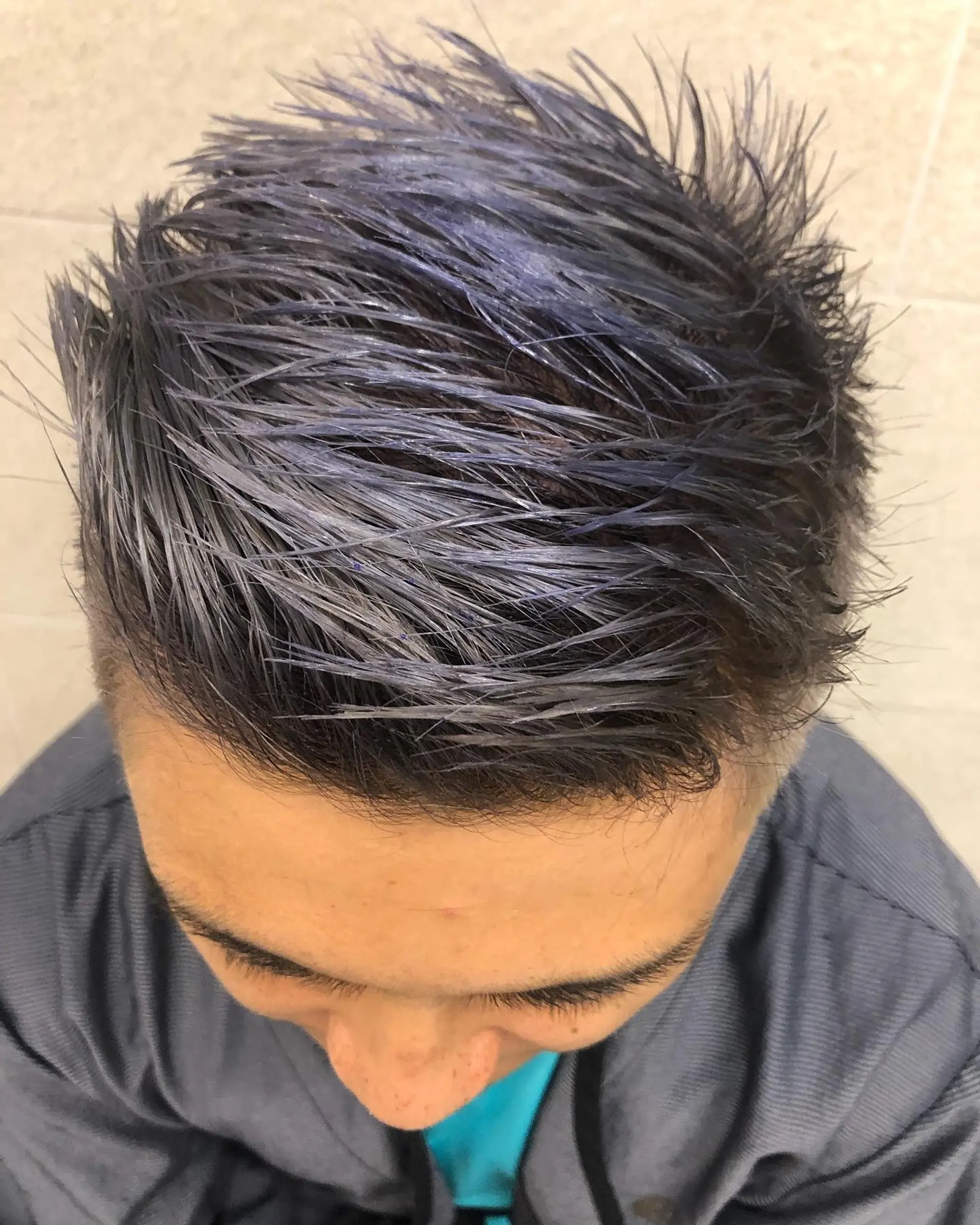 A short, piecey textured haircut finished in a cool slate grey with subtle blue undertones. 1