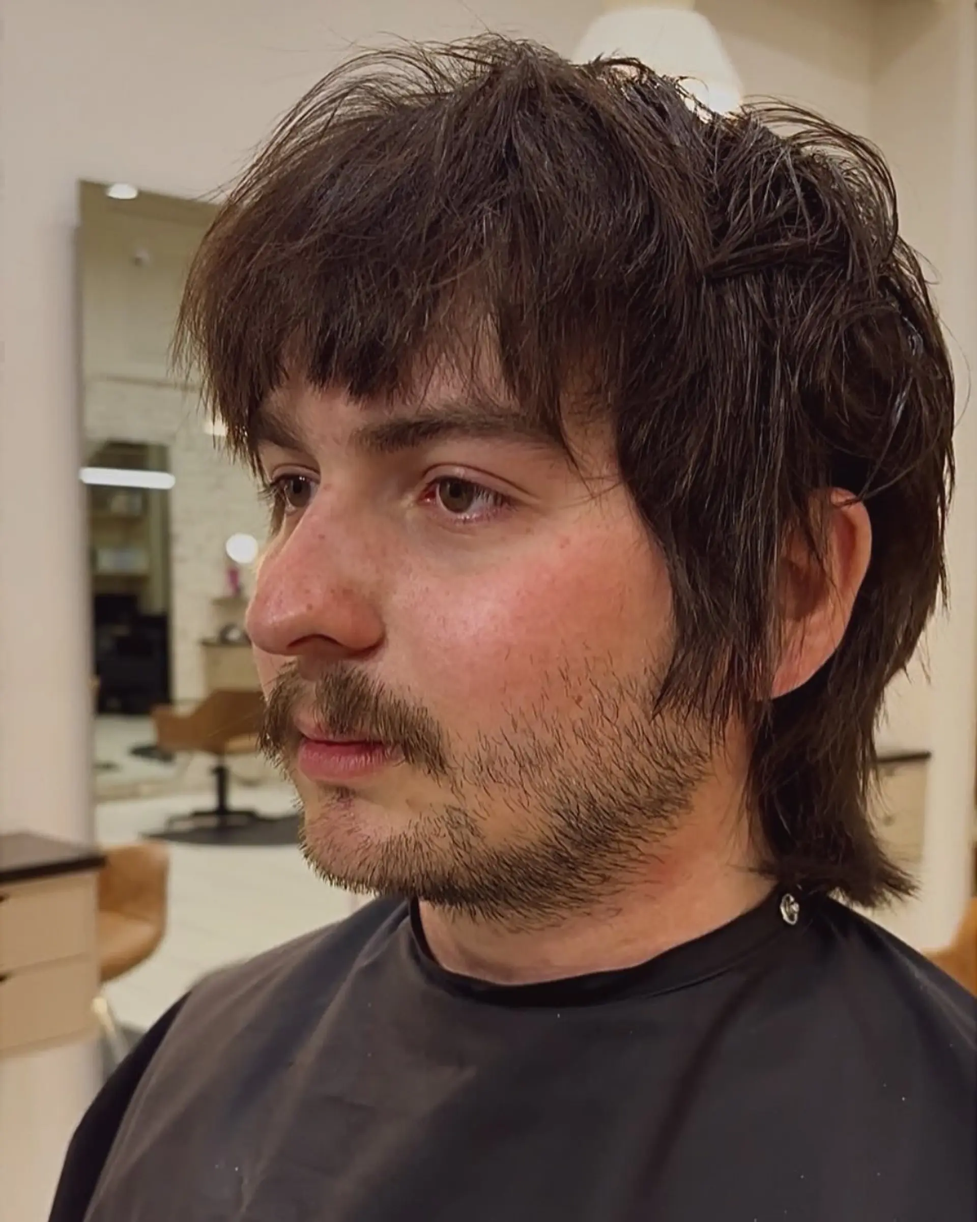 A modern shaggy mullet featuring textured bangs, piecey layered crown, and feathered length covering the nape. 1