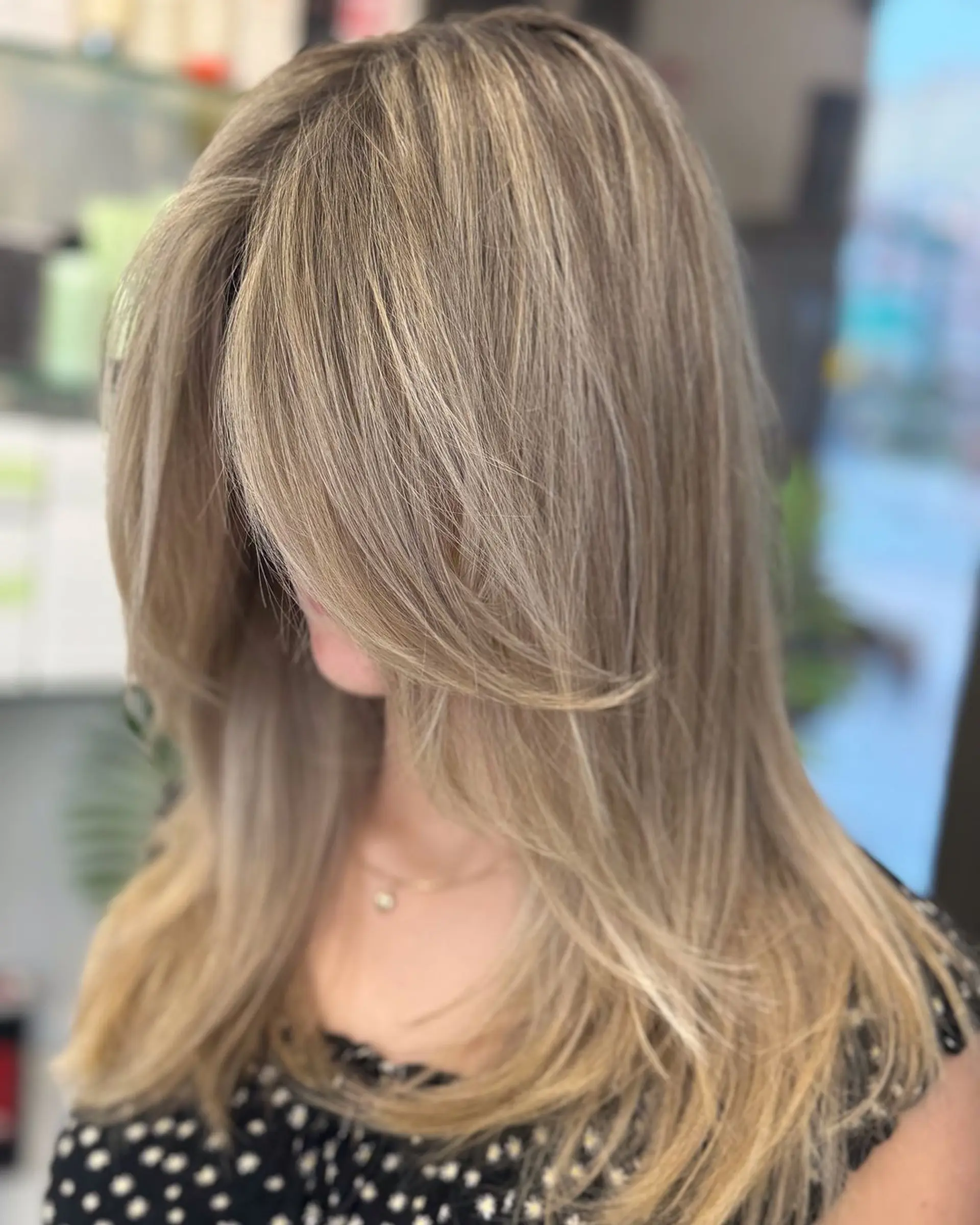 Stunning blonde hairstyle with straight texture, medium length, soft layers, and side-swept bangs featuring multi-toned blonde shades. 1