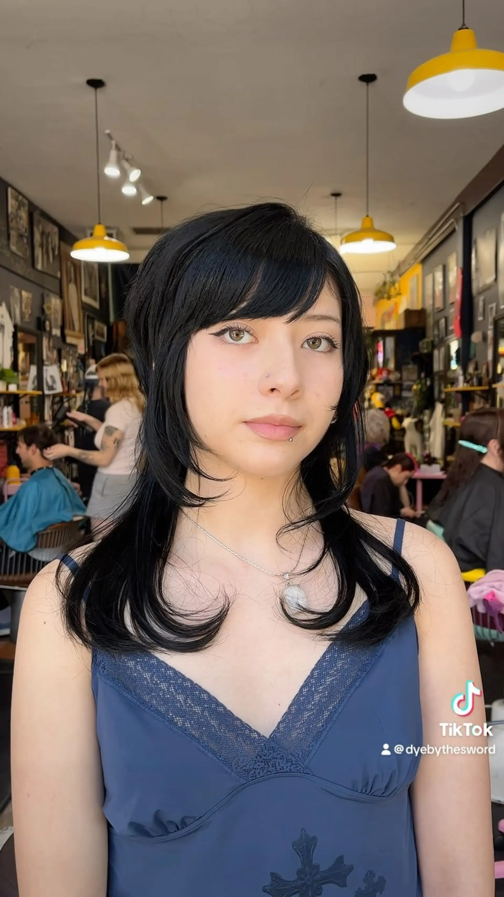 A jet black medium-length shag featuring feathered face-framing layers, side-swept bangs, and flipped-up curved ends. 1