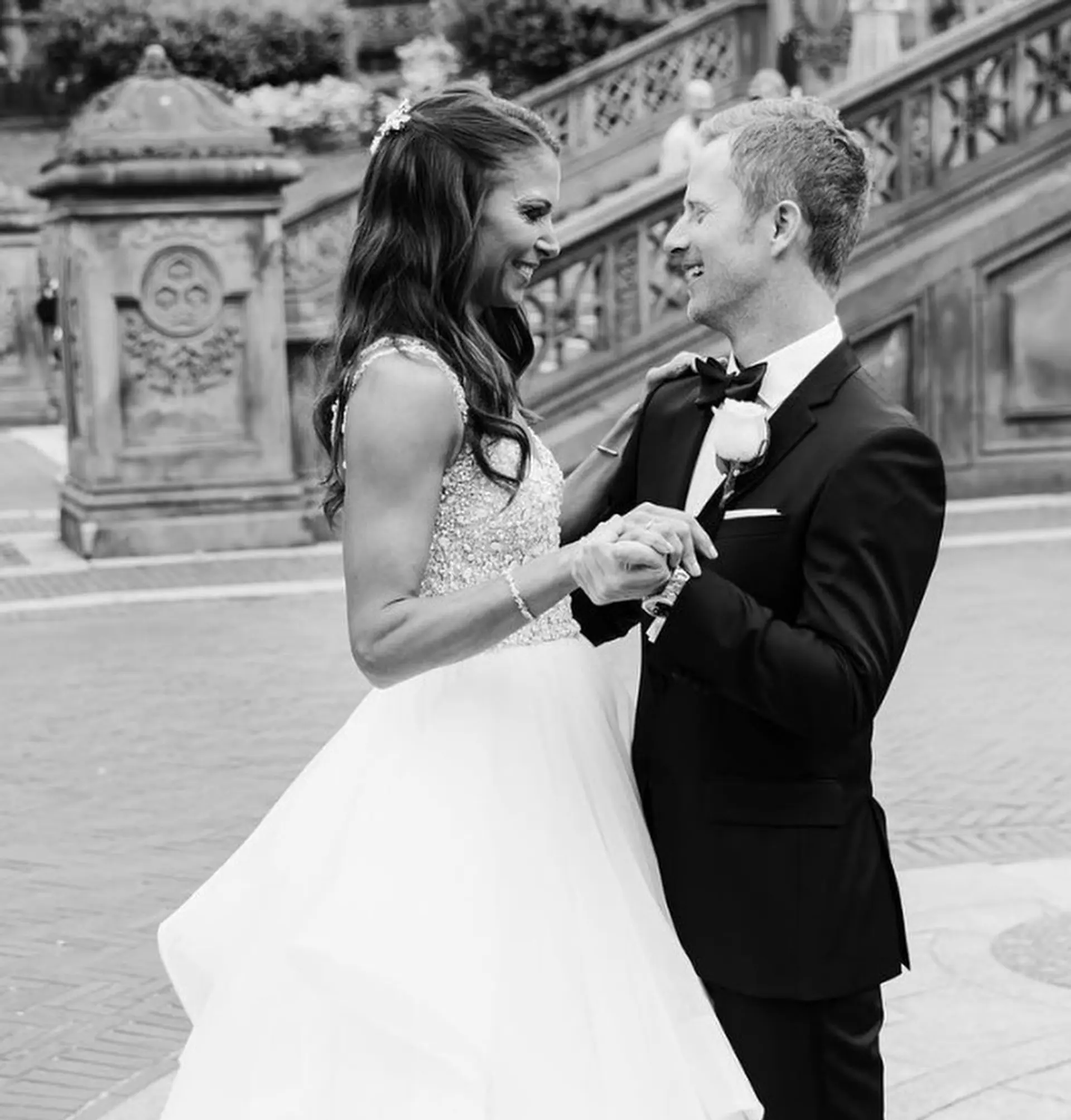 Long brunette hair styled into gentle, voluminous waves with a half-up style. Features soft waves and a delicate hair accessory, creating a romantic bridal look. 1