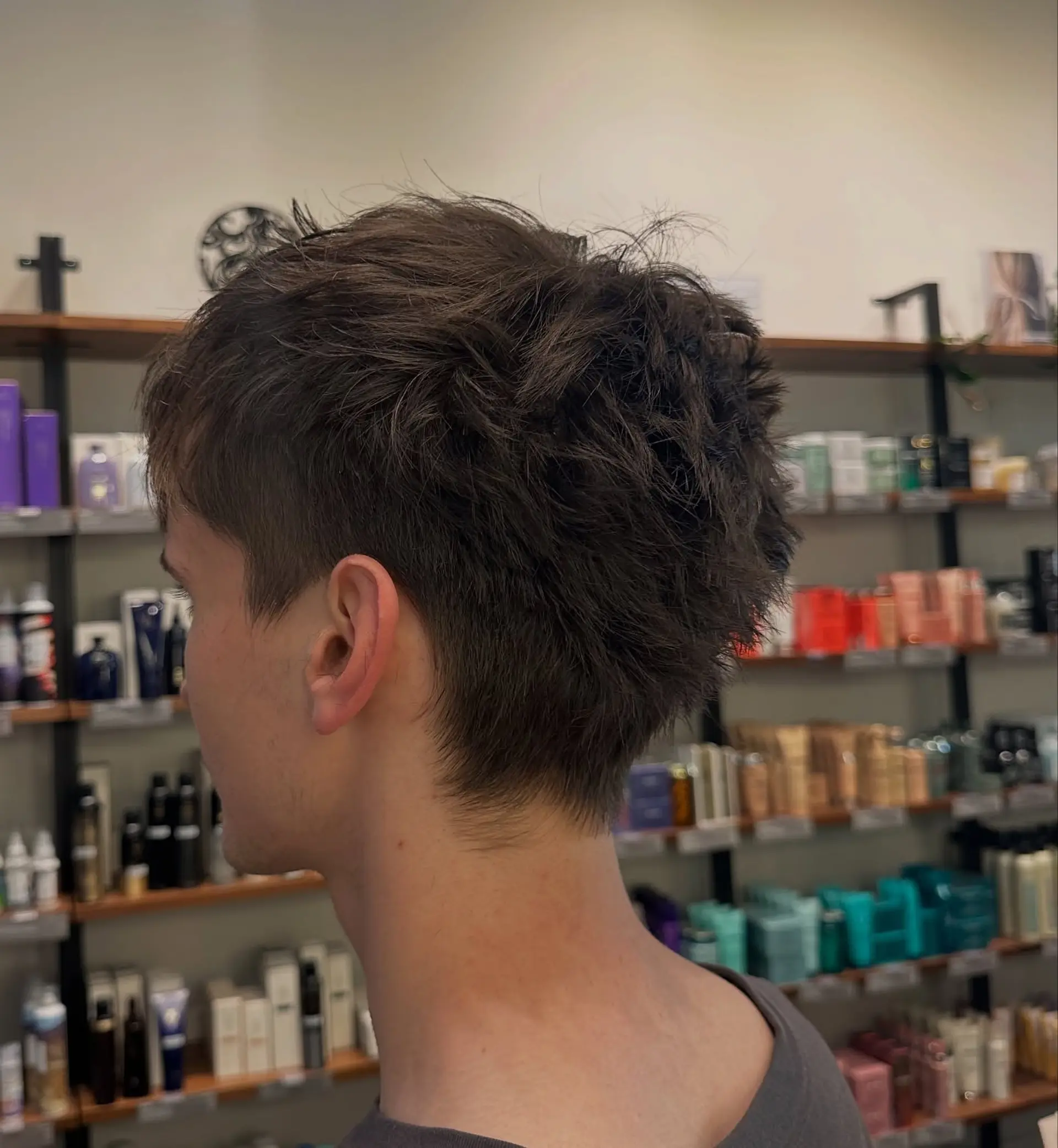 A short, heavily textured crop featuring piecey, choppy layers on top for volume and movement, complemented by a soft, natural taper around the neckline and ears. 1
