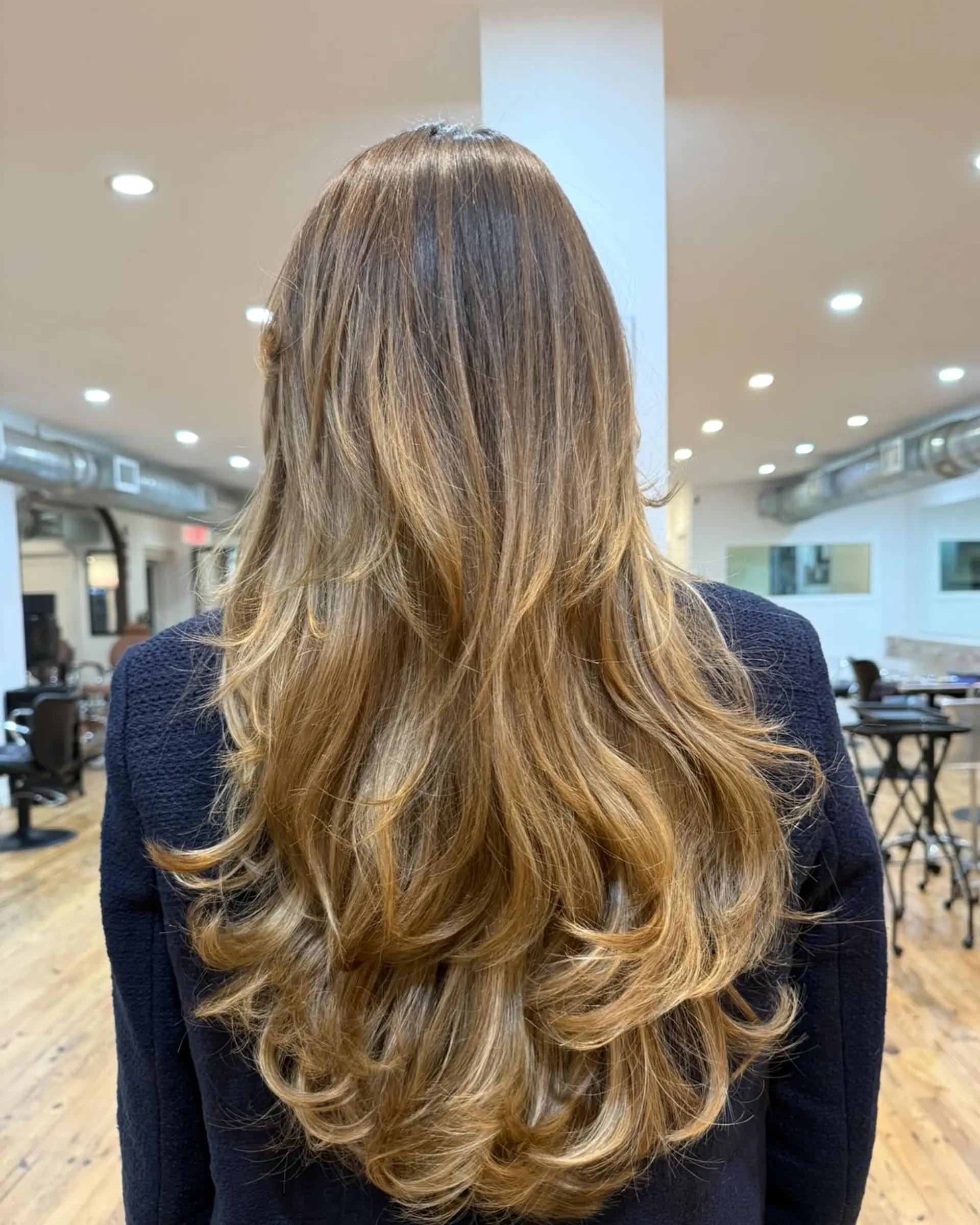 Long, wavy hair with soft layers and a honey blonde balayage. 1