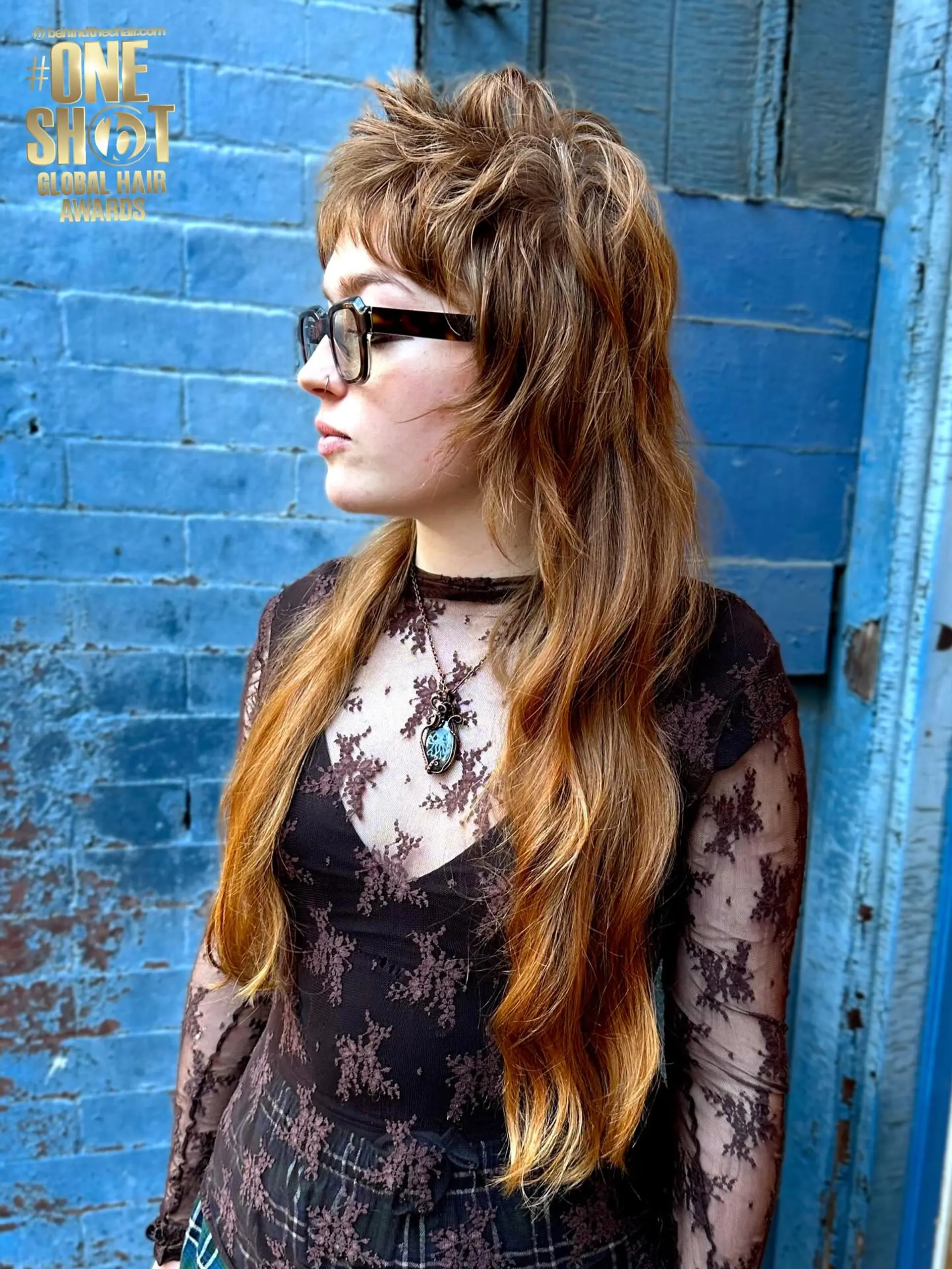 A textured long shag mullet featuring choppy, feathered layers on top, short textured bangs, and flowing lengths down the back. 1