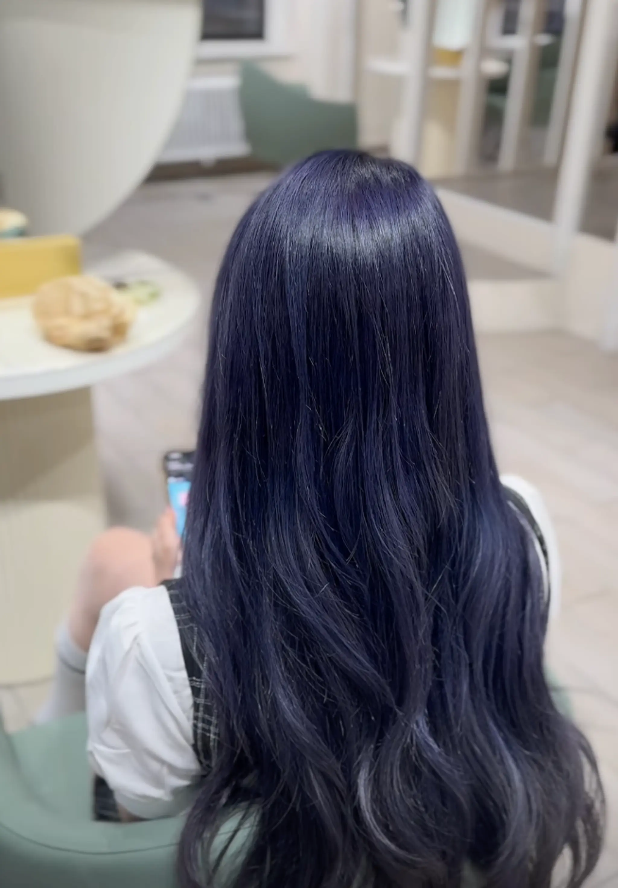 Long, wavy, dark blue hair with a silky texture and loosely defined waves.