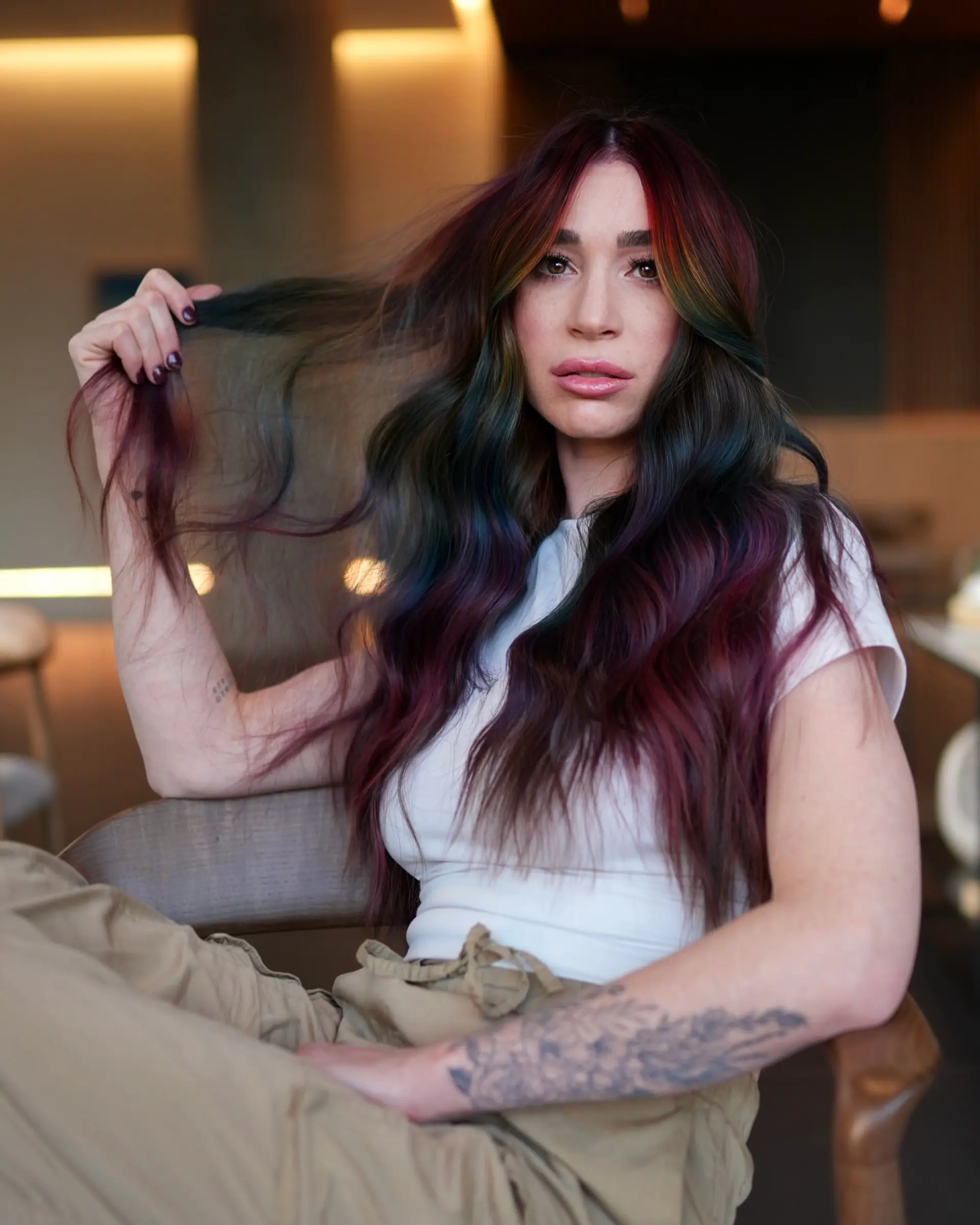 Long dark wavy hair accented with vibrant jewel-toned rainbow ribbons throughout. 1