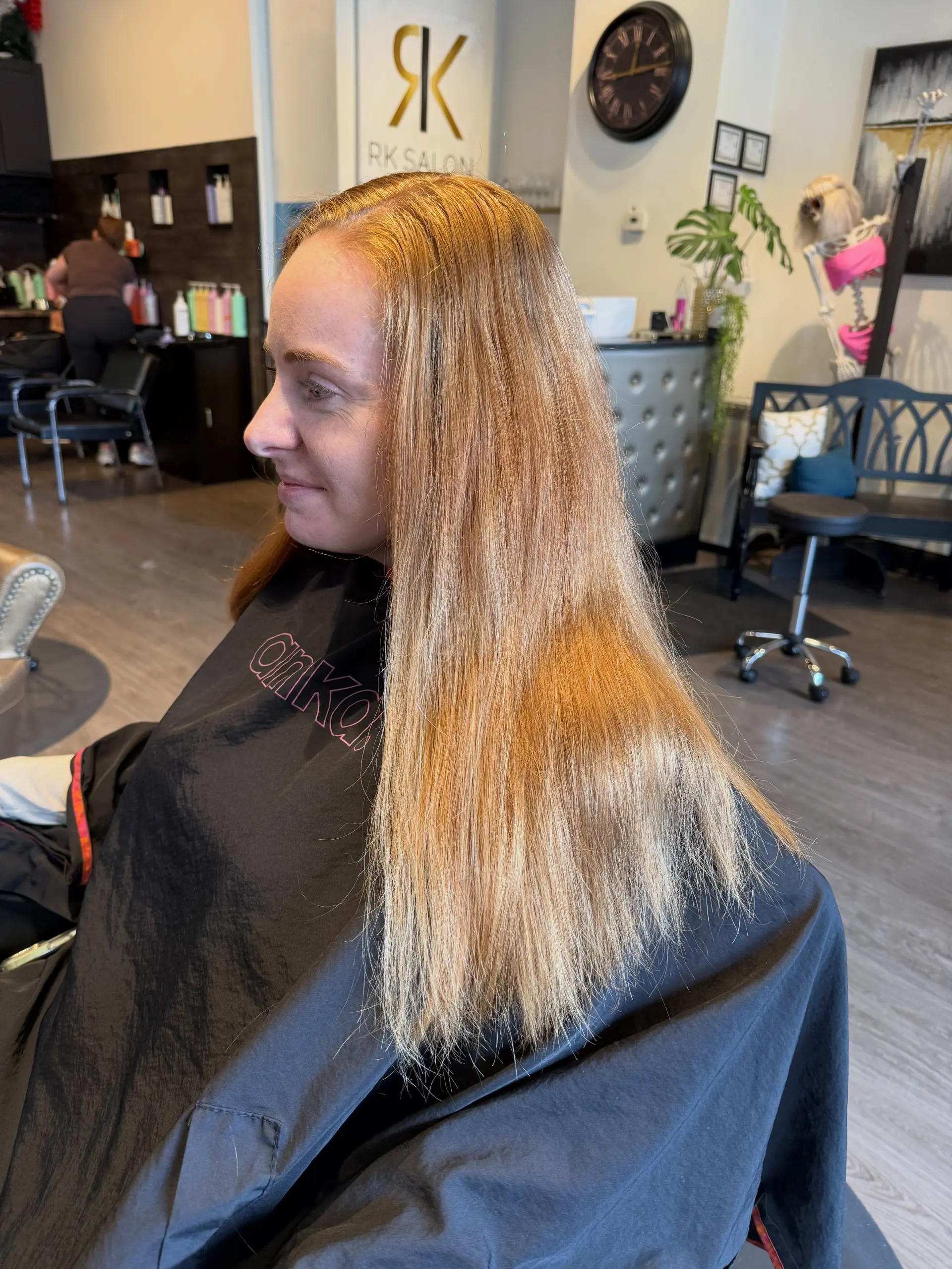 Long straight hair enhanced with warm copper foil highlights and a smooth blowout finish. 1
