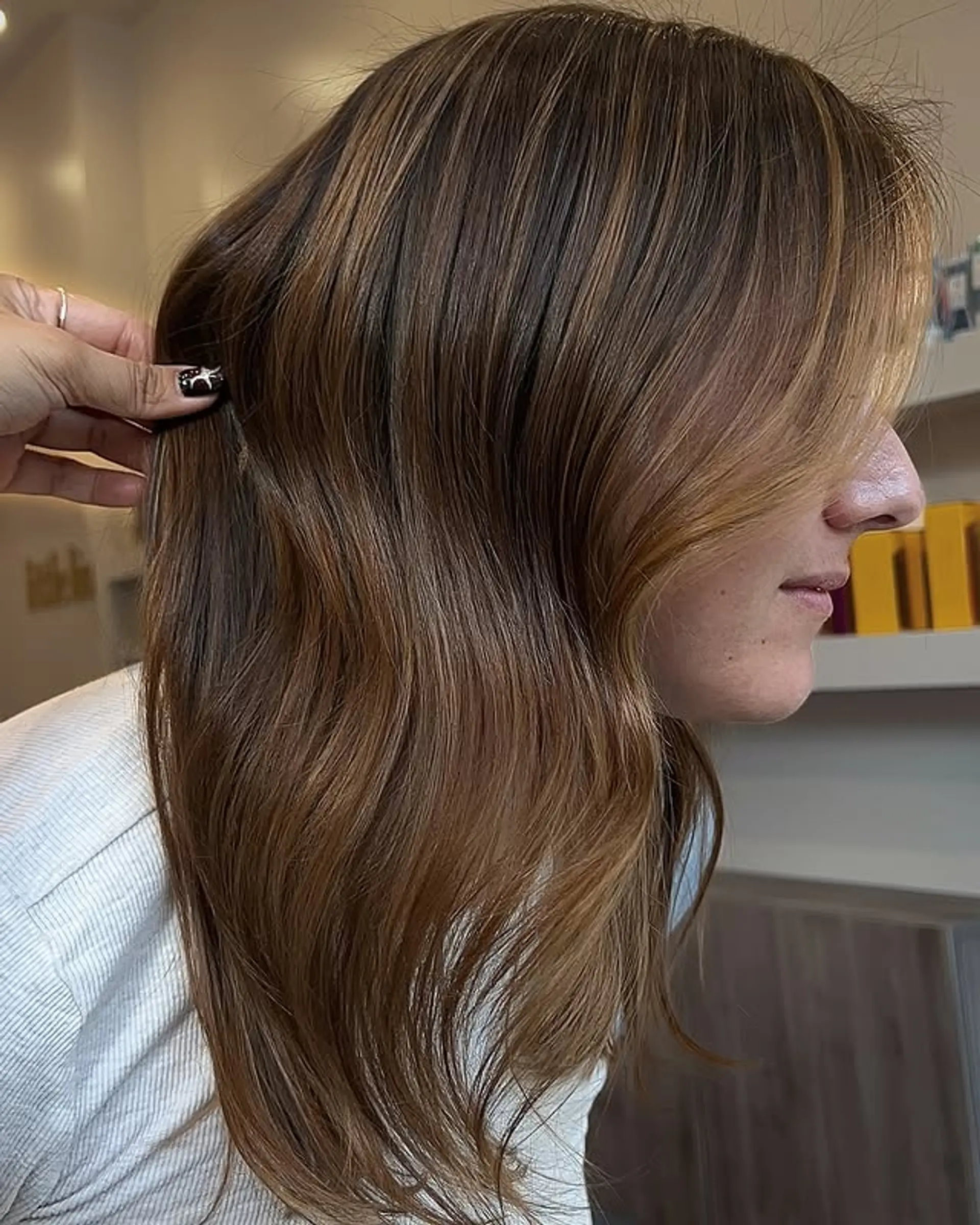 A medium-length wavy hairstyle with a caramel swirl balayage. 1