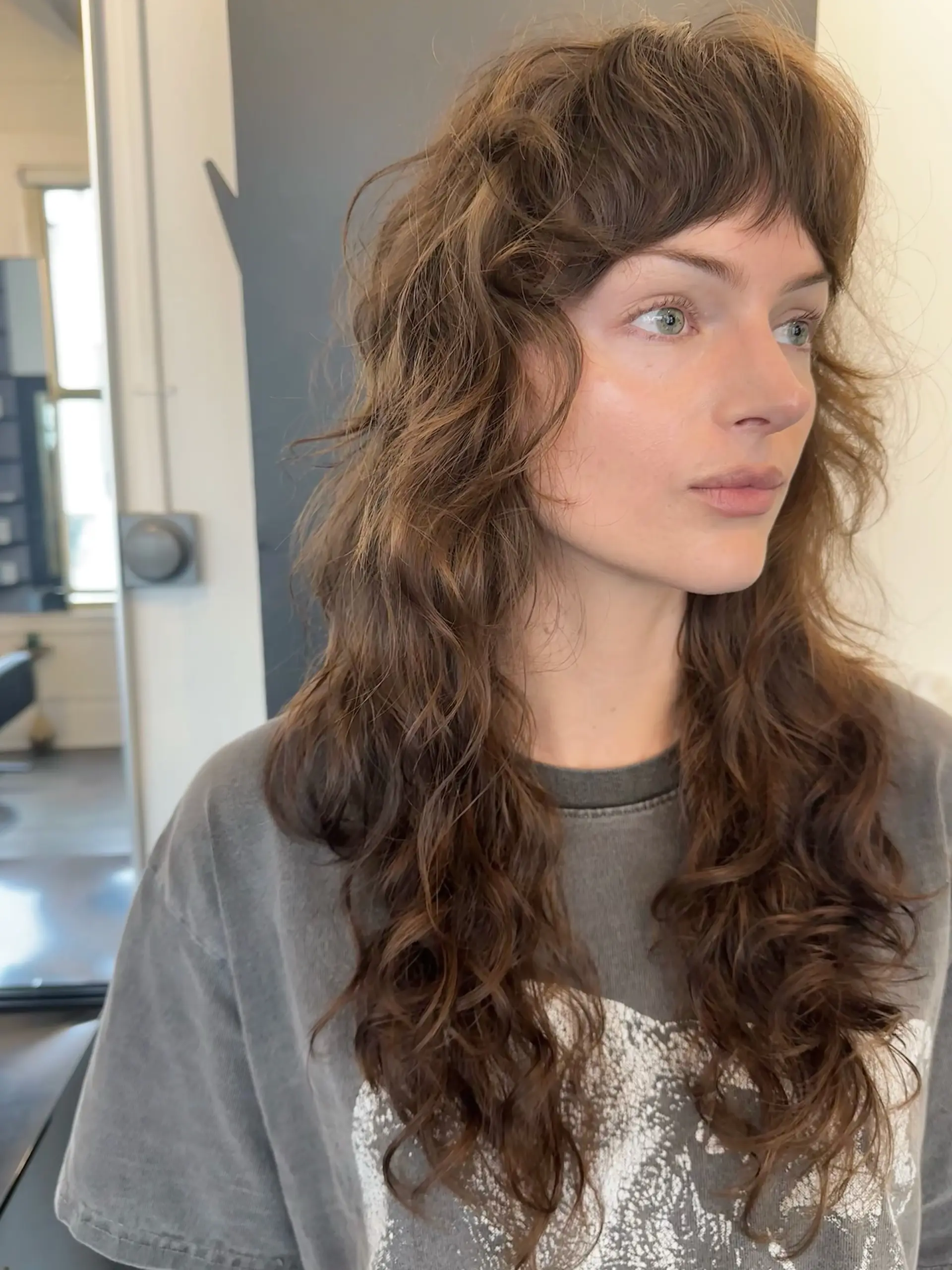 A textured razor-cut shag with soft fringe bangs and cascading wavy layers. 1