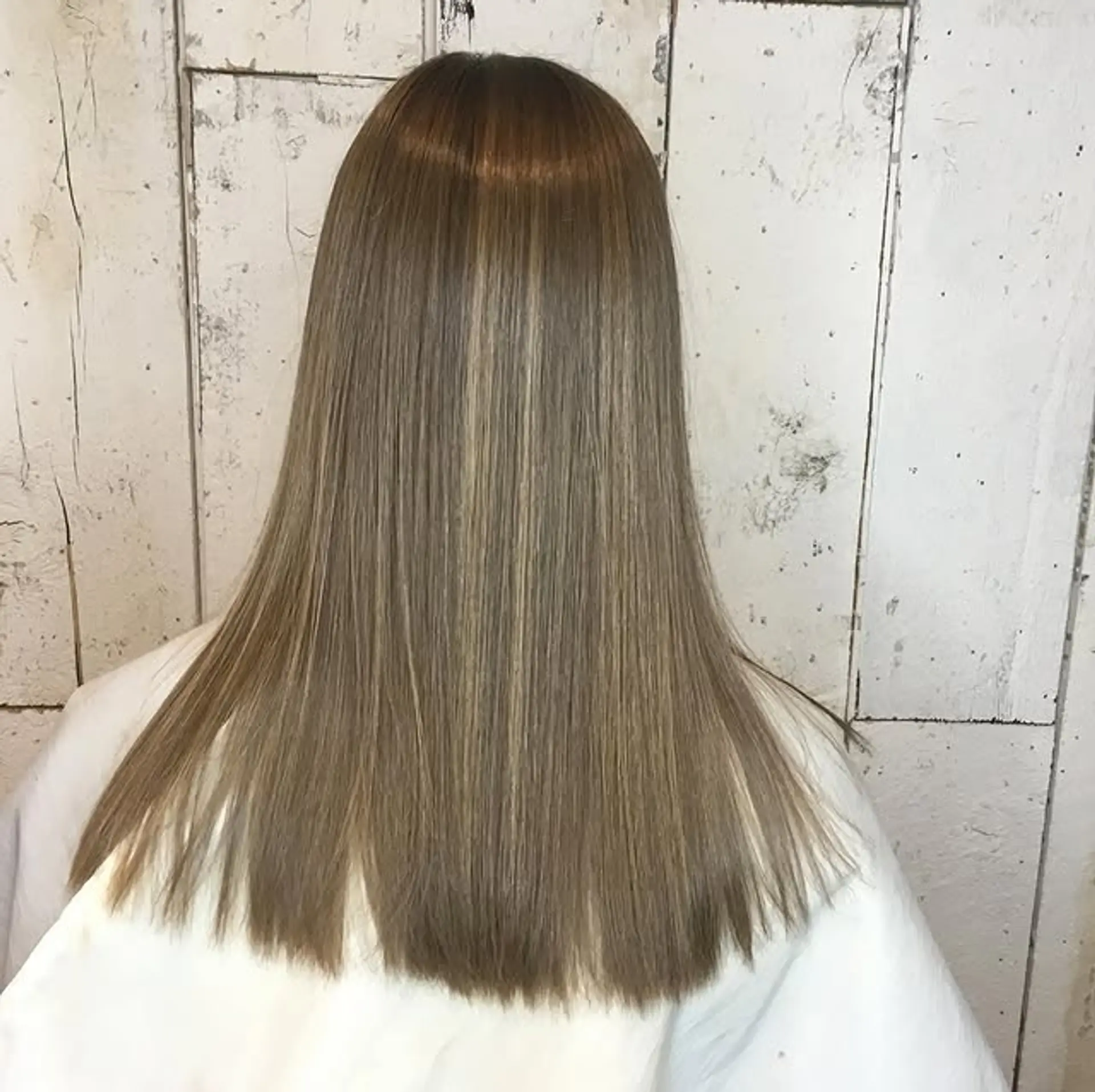 A sleek, straight, medium-length hairstyle with subtle blonde highlights. 1