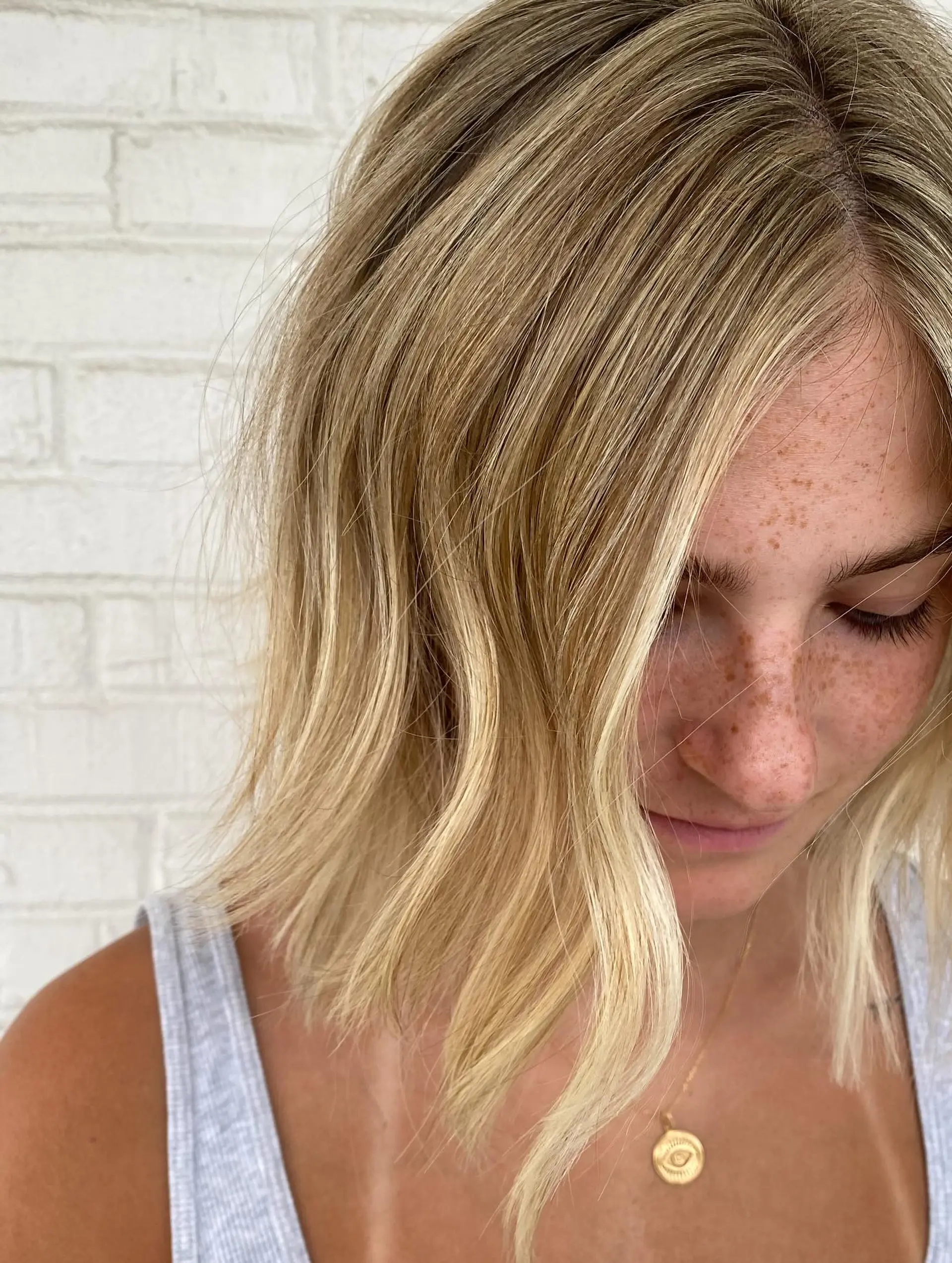 A textured wavy bob featuring dimensional bright blonde highlights and subtle root depth. 1