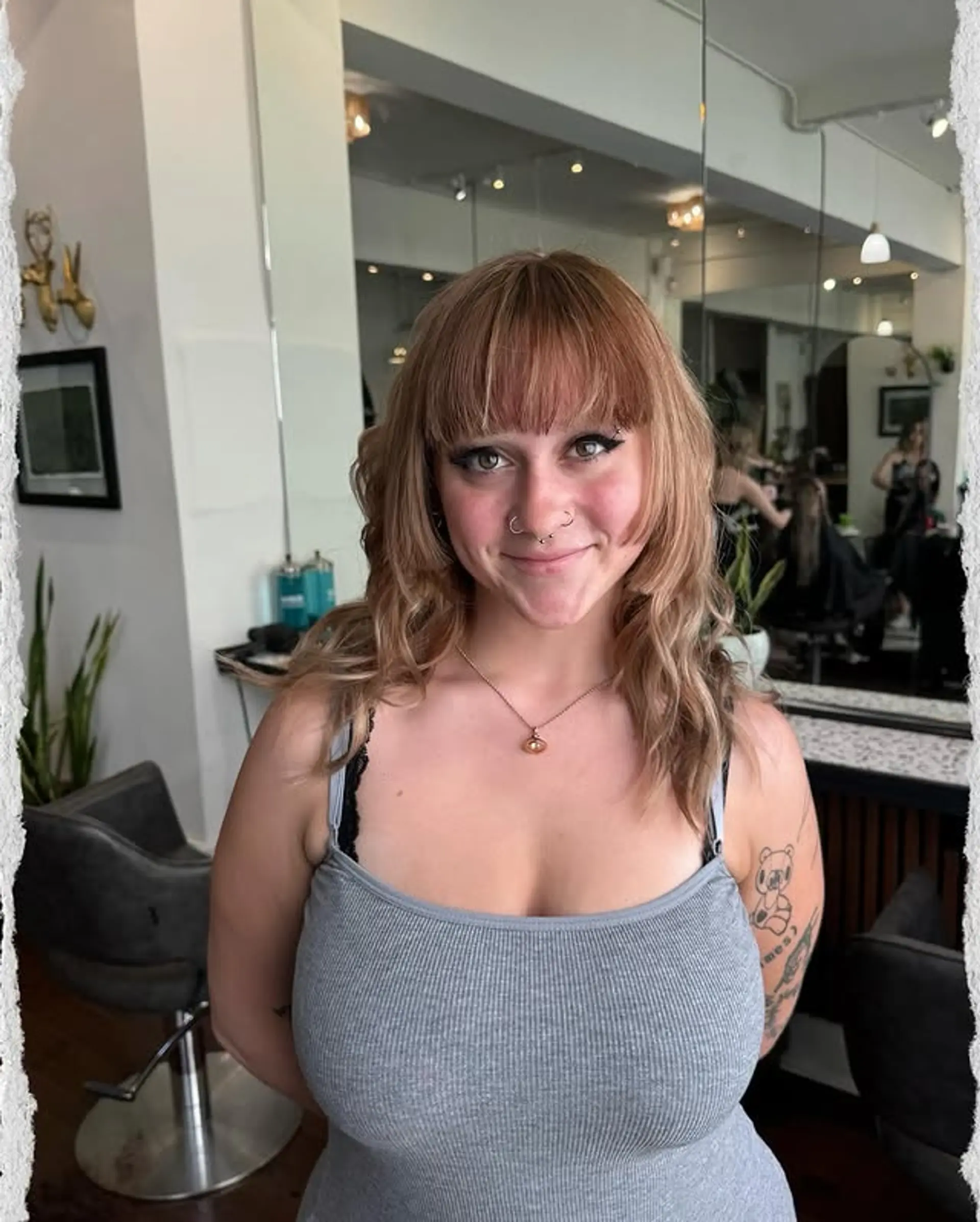 A trendy medium-length hairstyle with curtain bangs, bronde waves, and face-framing layers. 1