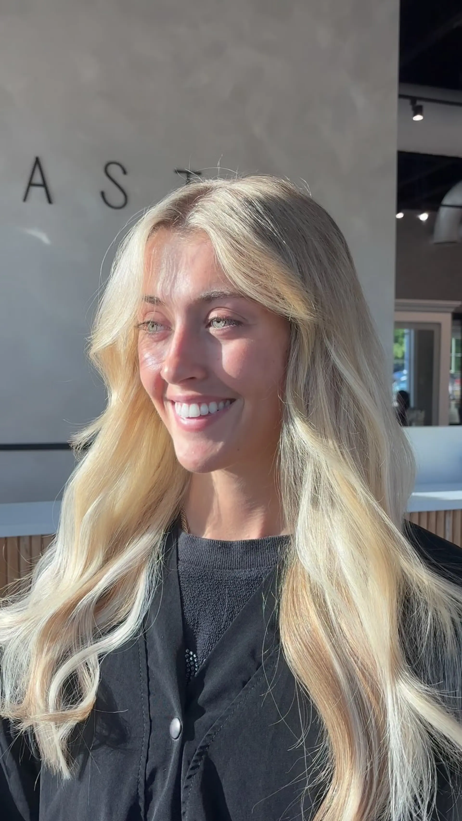 Long, flowing blonde locks styled with soft dimensional waves and face-framing curtain layers. 1
