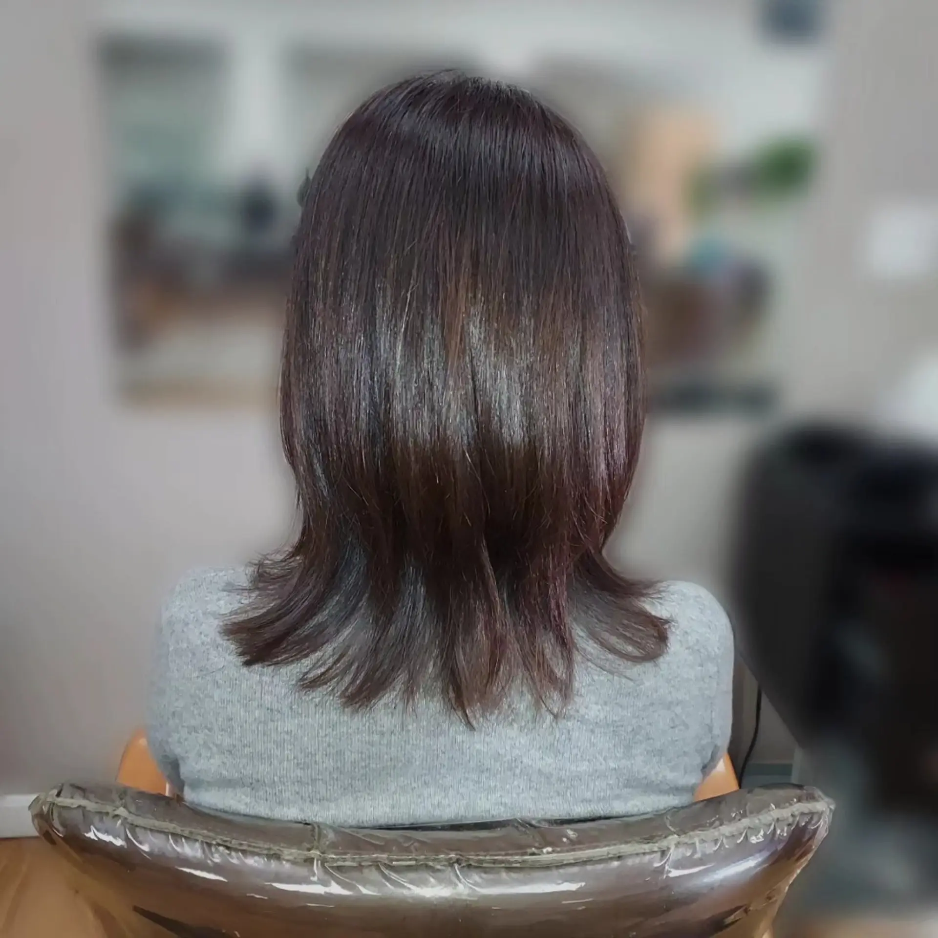 A sleek mid-length haircut featuring soft layers and textured, subtly flipped ends. 1