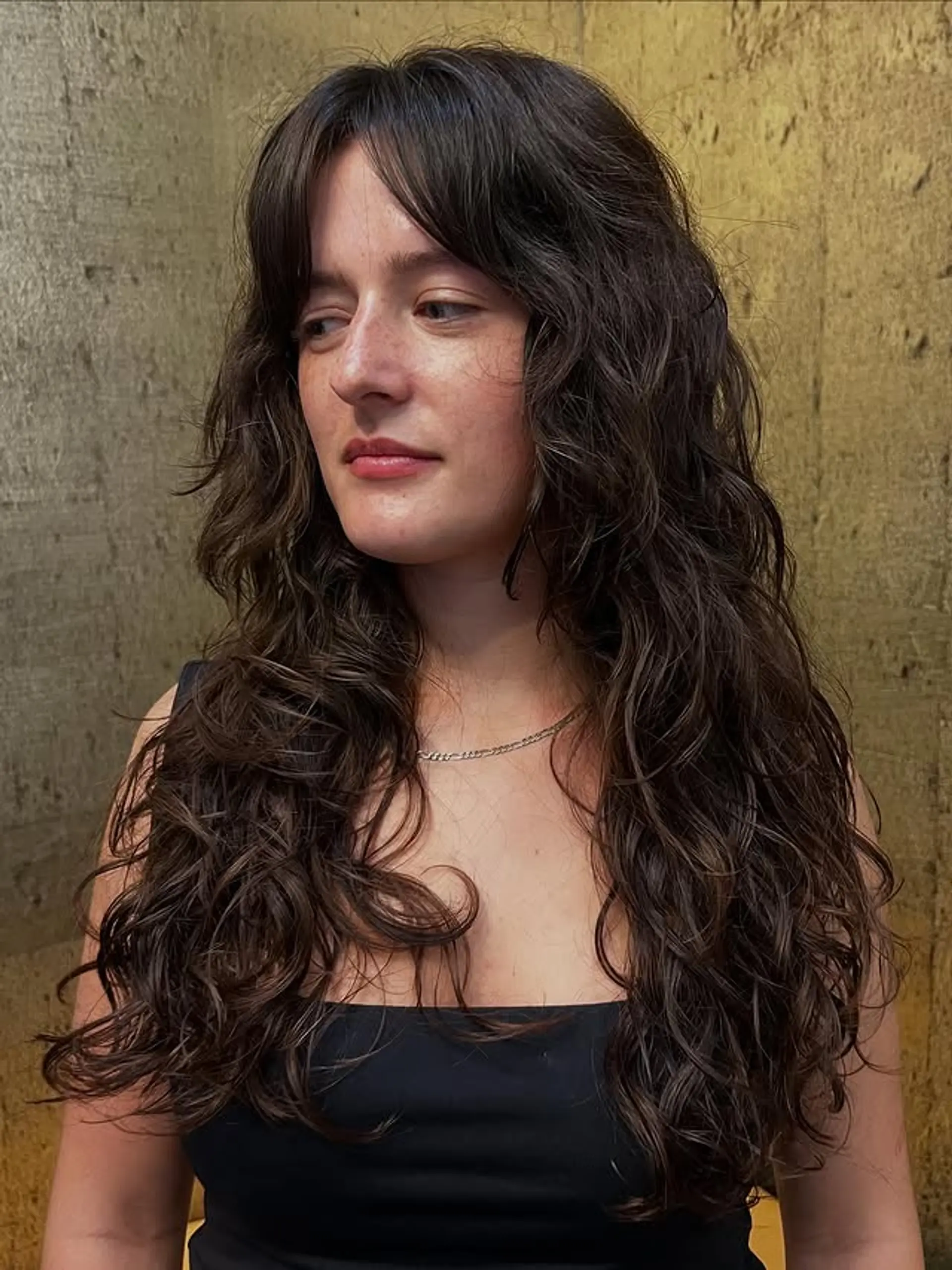 A long shaggy hairstyle with layered texture and face-framing curtain bangs. 1