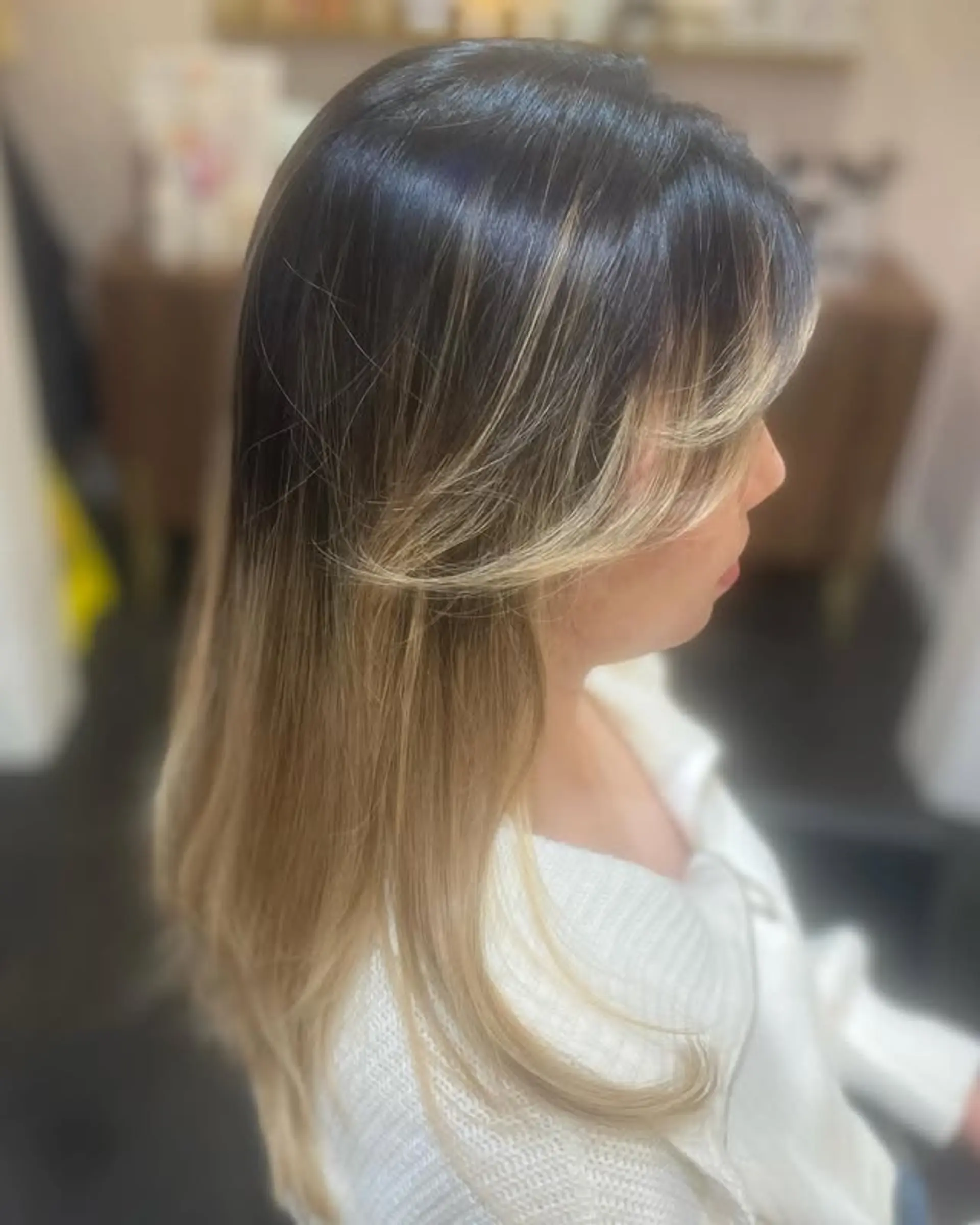 A medium-length, layered hairstyle with soft, face-framing curtain bangs. The hair is styled straight and smooth, with a subtle inward curl at the ends. 1