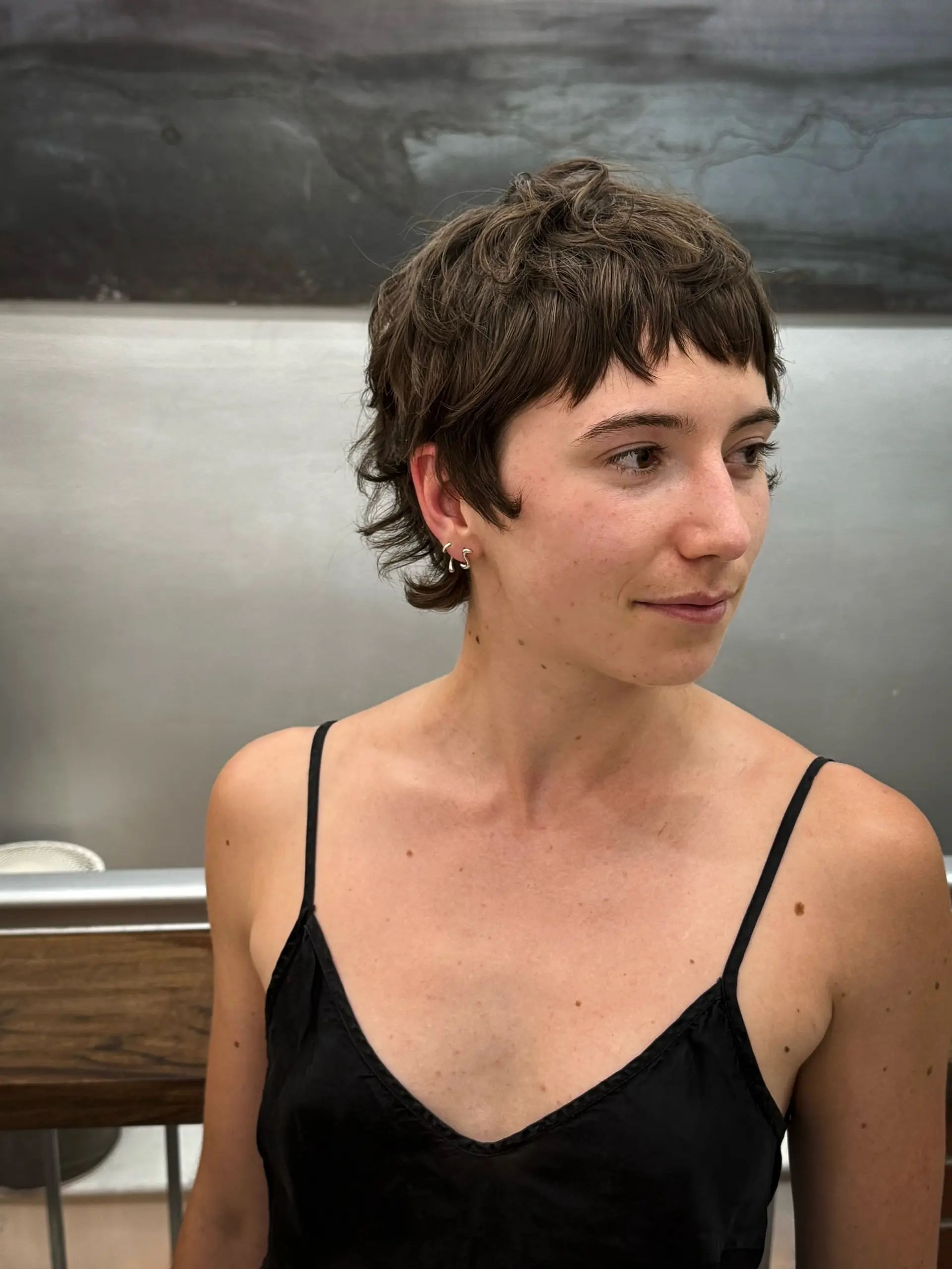 A short, wavy shag haircut with choppy layers and very short, micro bangs. 3