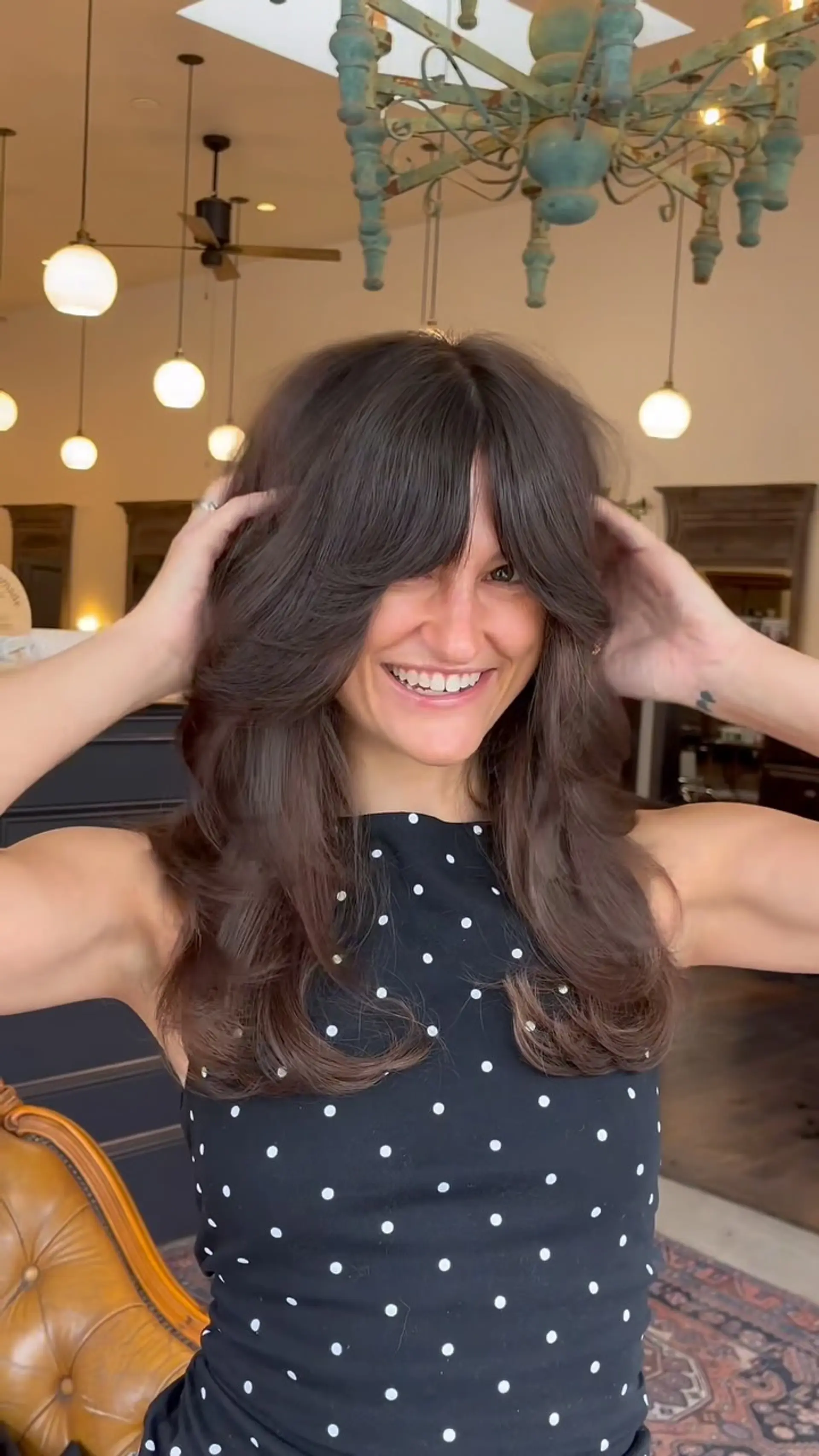Voluminous long layered haircut featuring feathered curtain bangs and smooth, bouncy outward curves. 1