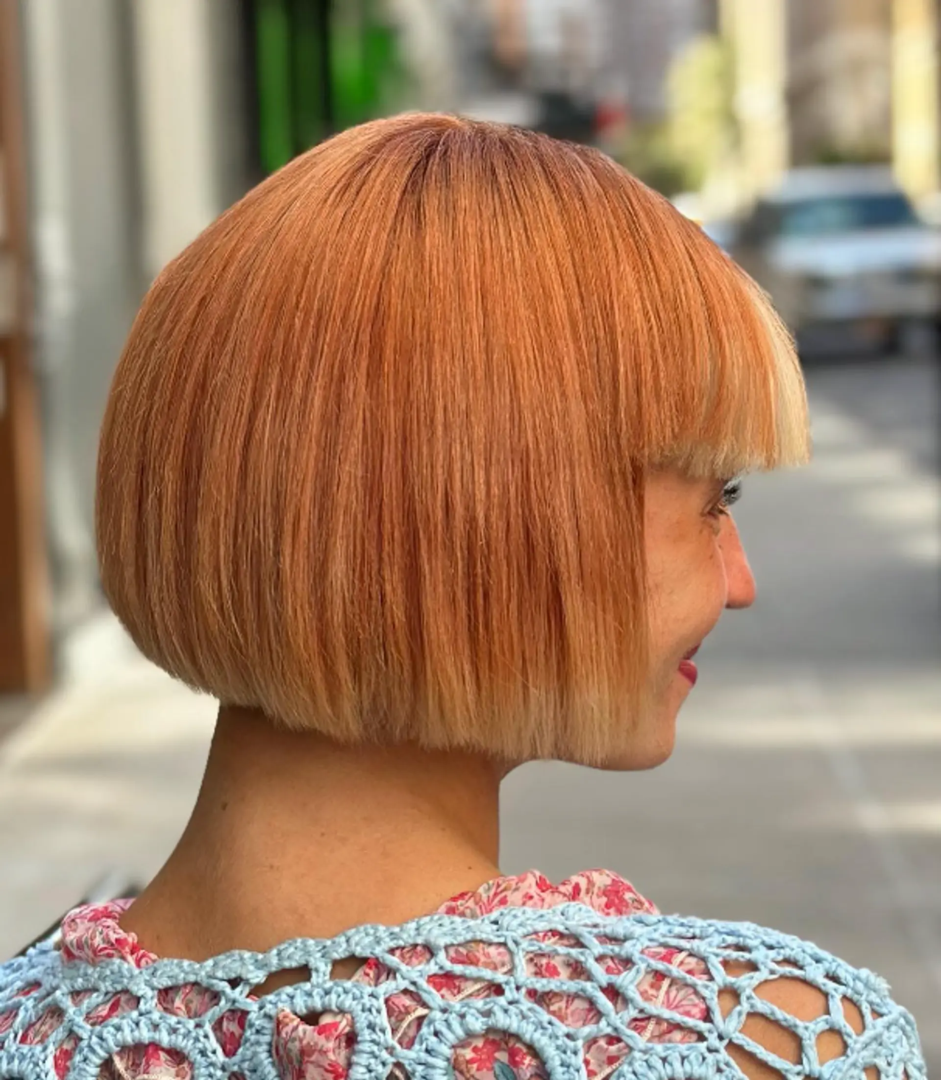 A short, straight, light orange bob with a blunt cut, straight fringe, glossy finish, and soft layers.


 2
