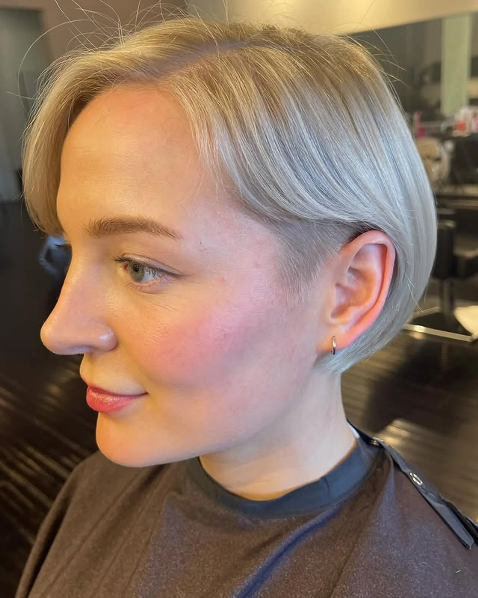 Woman with a platinum blonde pixie buzz cut making a daring statement - Preview 1