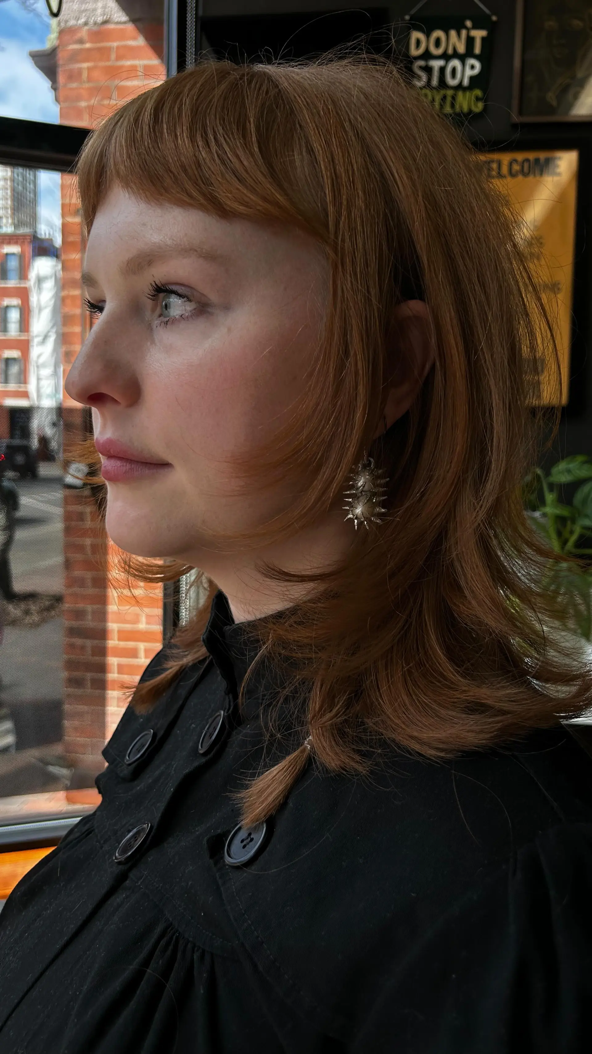 A layered, shoulder-skimming copper cut featuring cropped baby bangs and soft, face-framing textured layers. 1