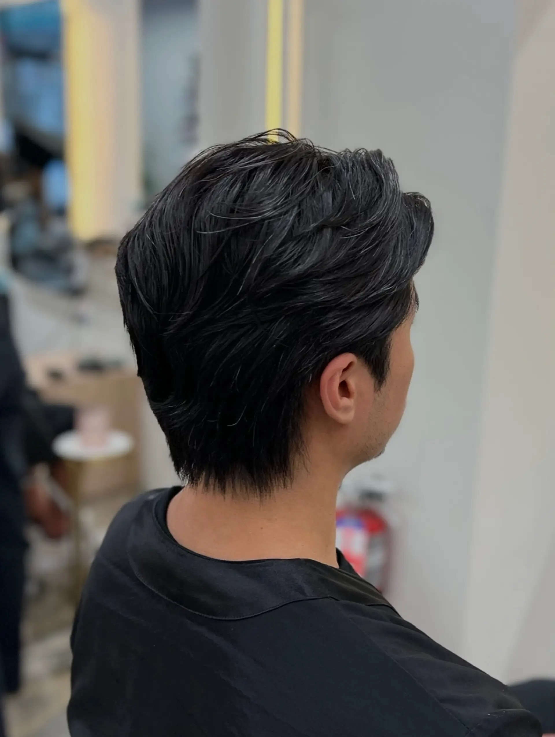 A short, layered haircut swept backward with soft texture on top and a clean, tapered nape. 1