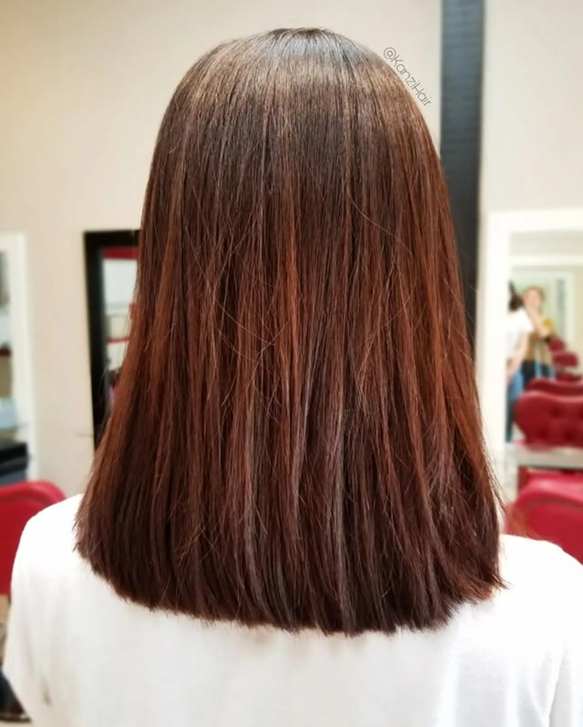 A sleek, medium-length blunt cut styled straight, showcasing a vibrant auburn color with subtle reddish-brown hues and a natural root blend. 1