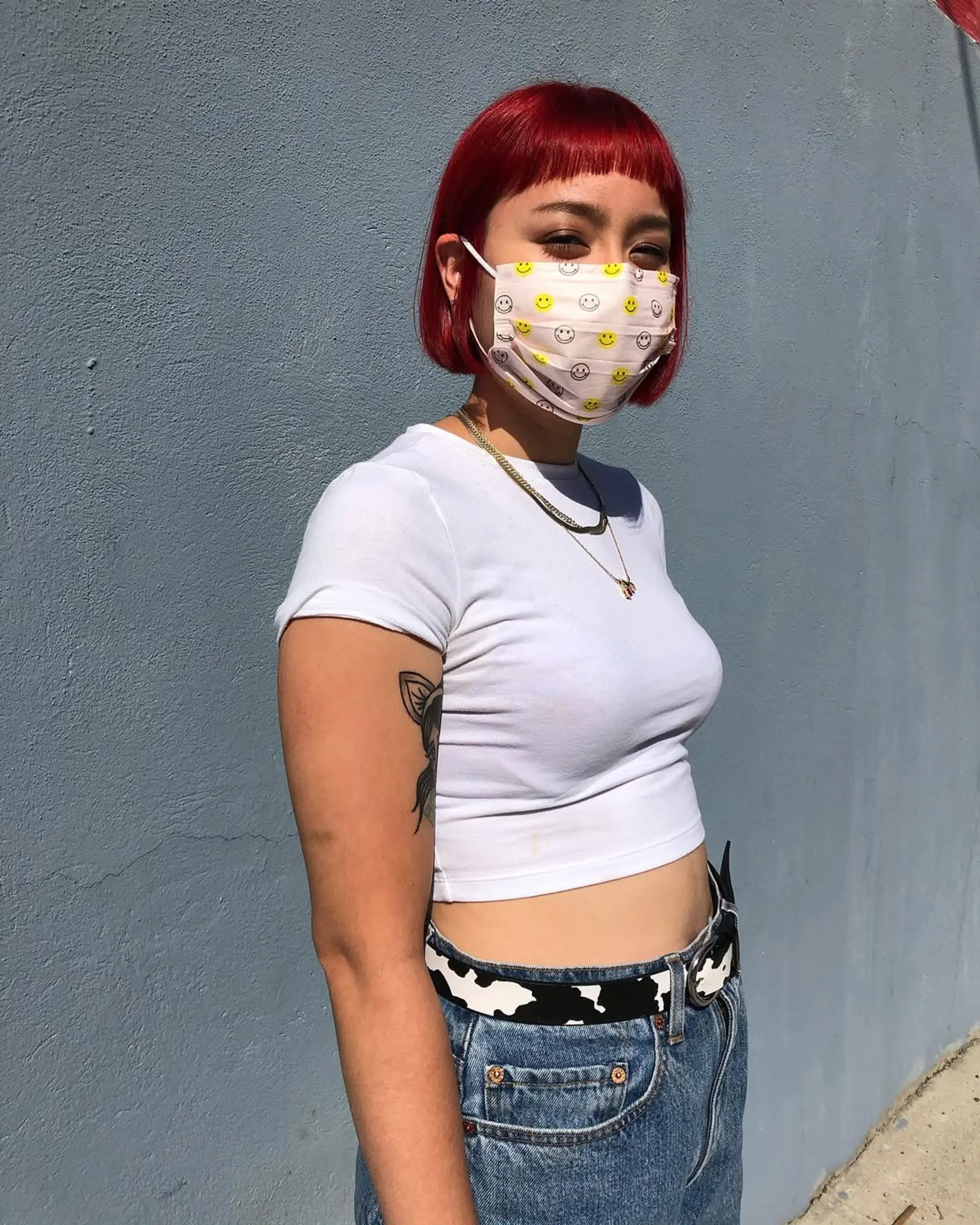 A vivid red, straight bob with blunt bangs at ear-length, featuring a sleek and glossy finish. 2